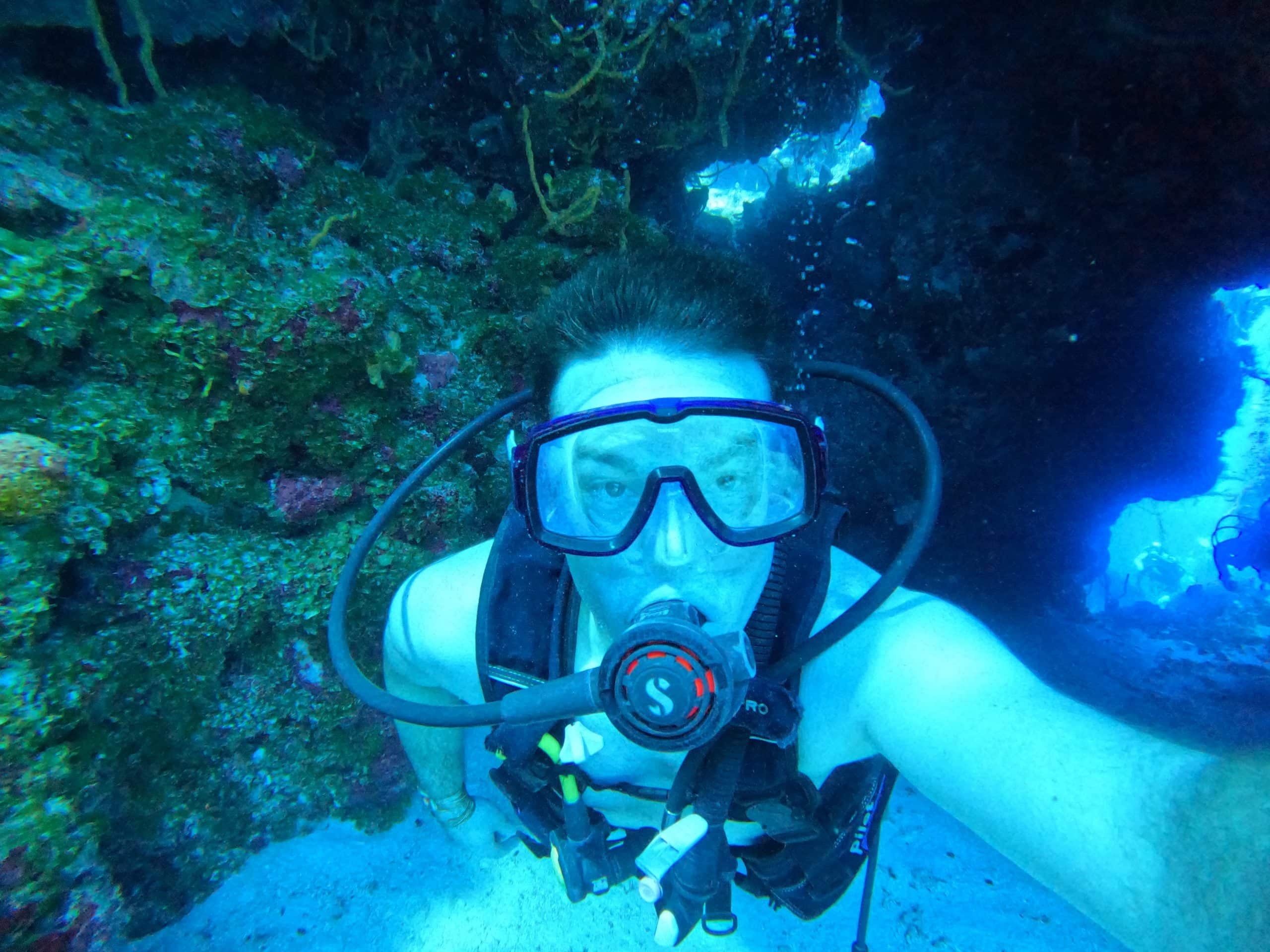 Scuba-Diving-Cozumel Scuba diver going through a swim through tunnel in Cozumel.