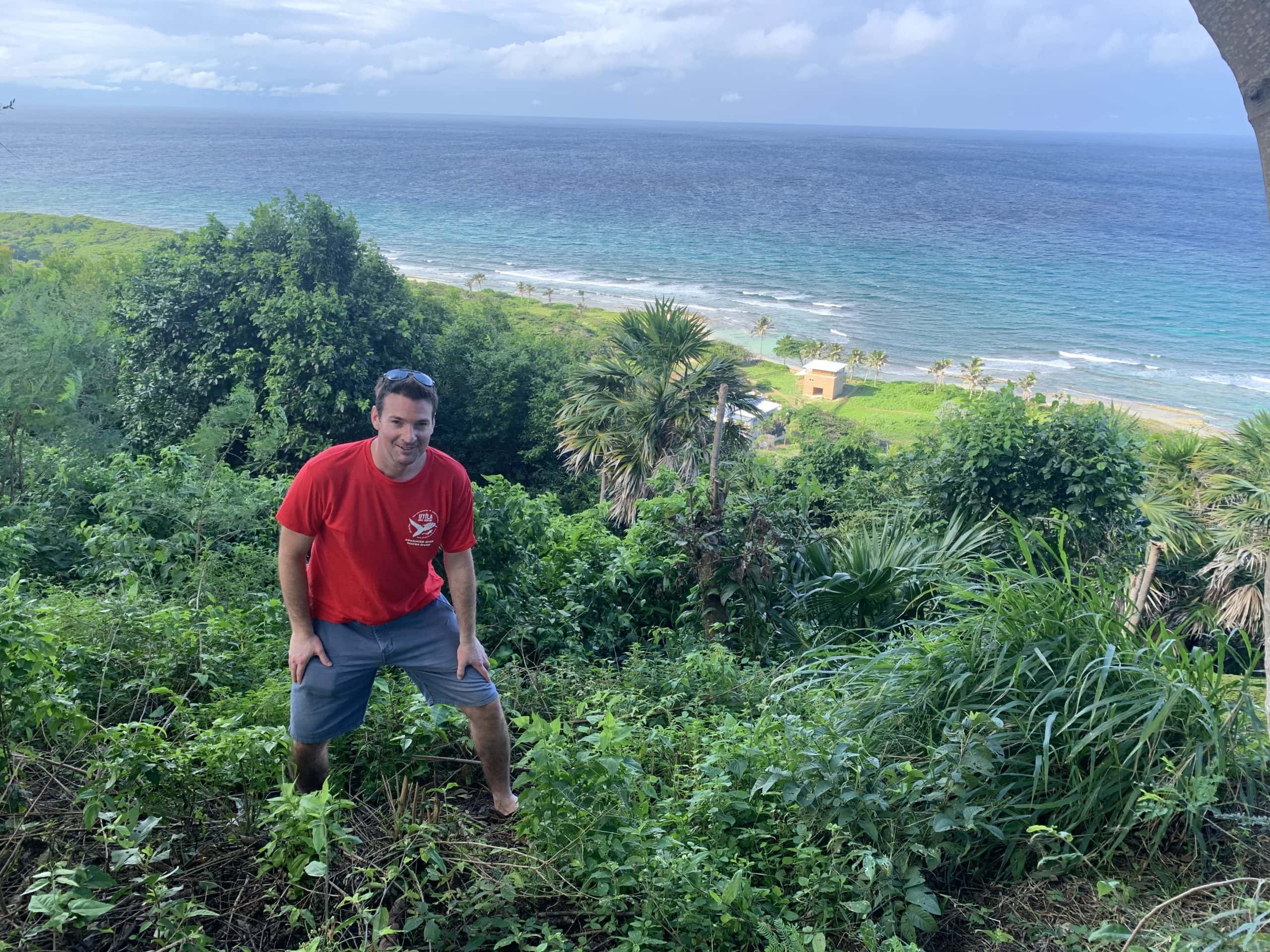 A man standing from the view point on Pumpkin Hill in Utila, Honduras.