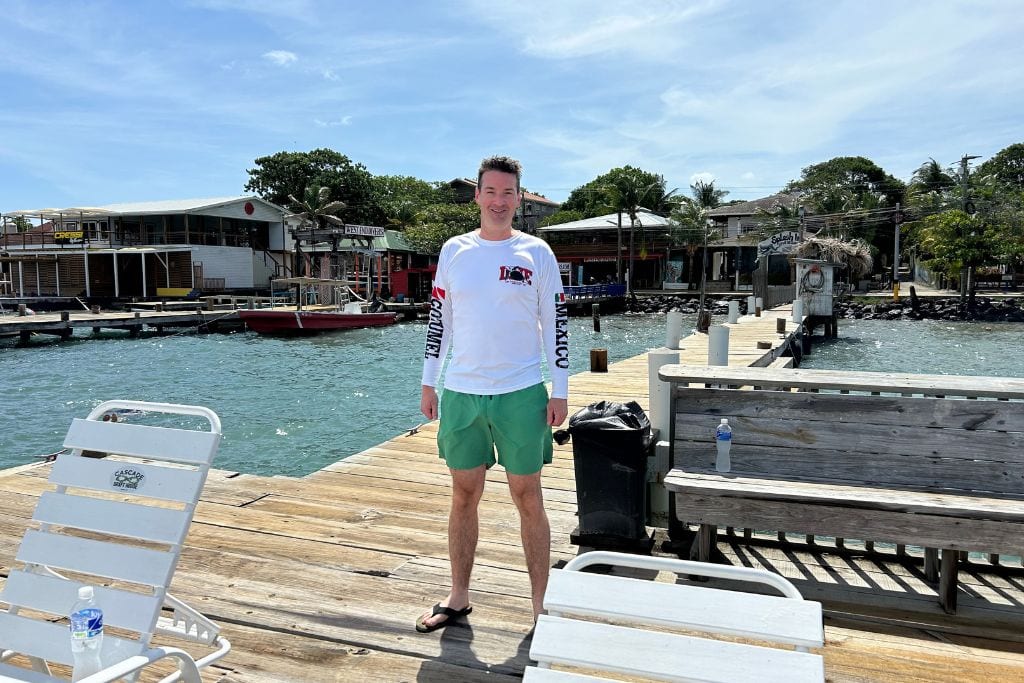 A diver standing on the dock outside of the Splash Inn Dive Resort in Roatan, Honduras.