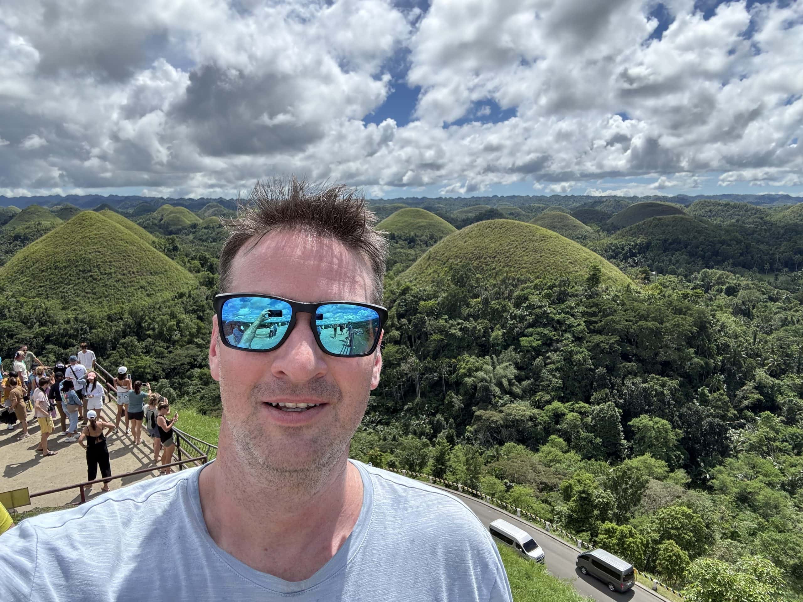 Ryan Gillard posing in front of the famous Chocolate Hills in Bohol, Philippines.
