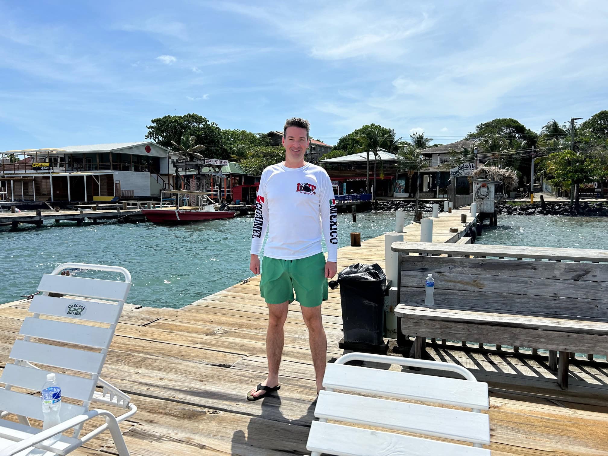 Bustling beachside street in West End, Roatan lined with dive shops and cafes