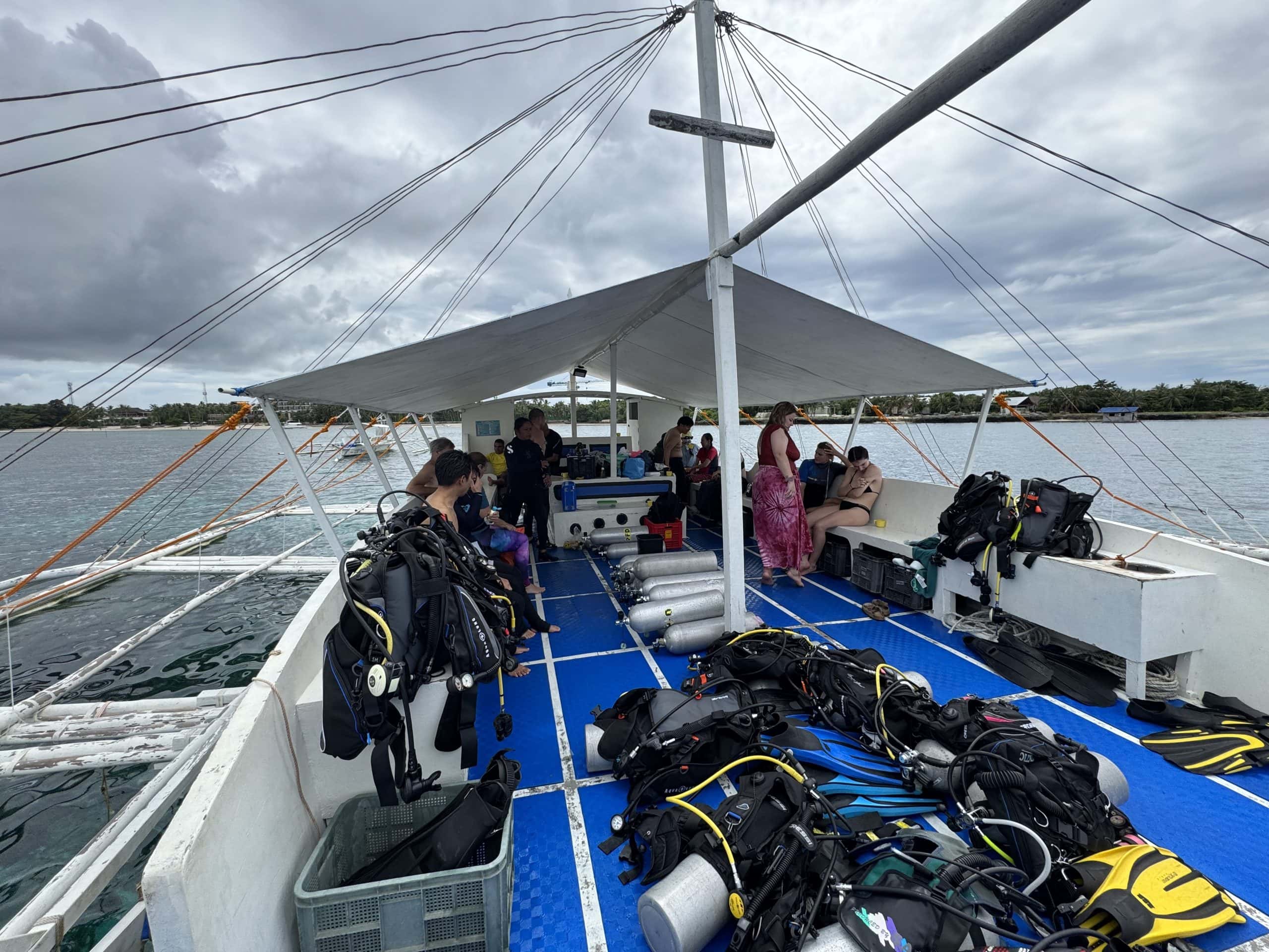 A scuba diving boat with turquoise waters at Alona Beach, Bohol — a top spot for scuba diving courses and nightlife.