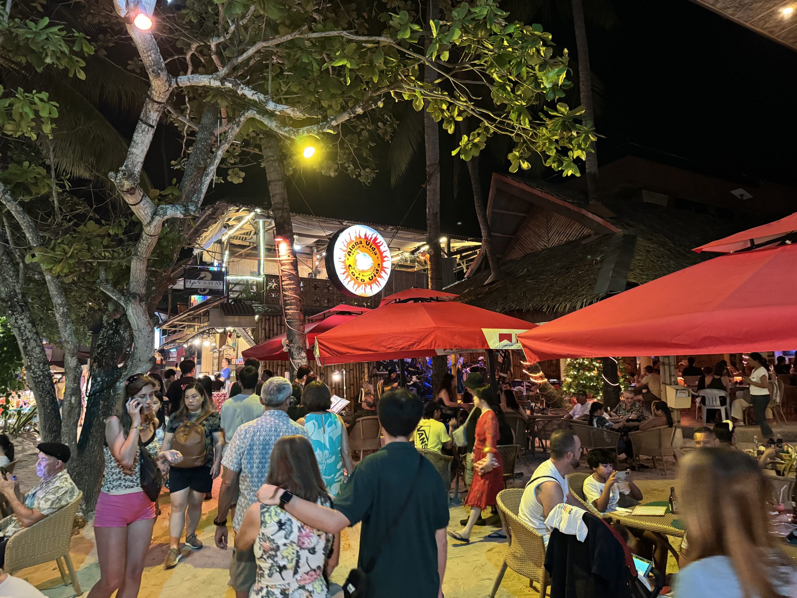 A crowded beach and restaurant on New Year's Eve in Alona Beach, Bohol, Philippines.