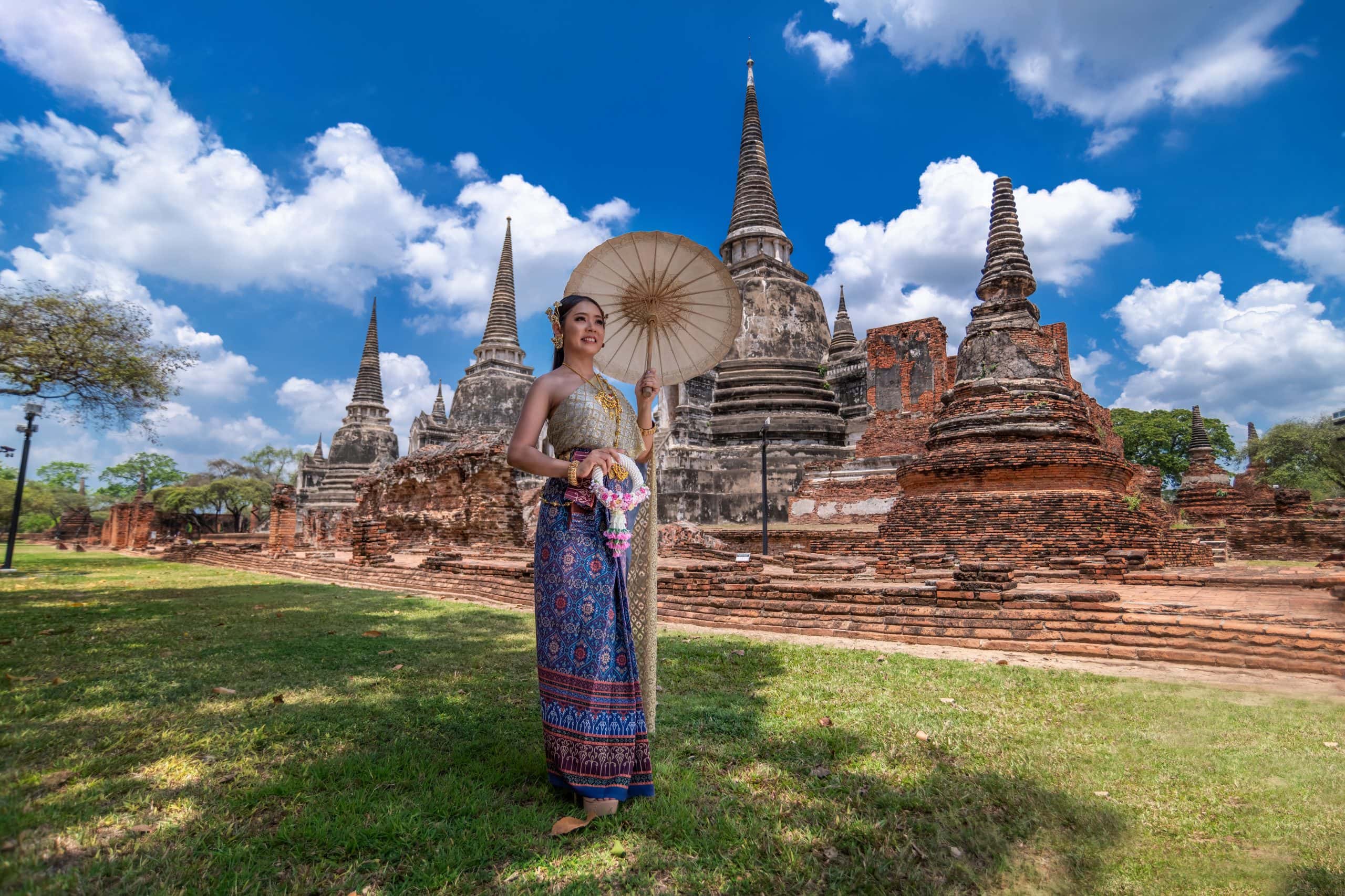 Thai woman in elegant traditional dress standing in a cultural heritage site