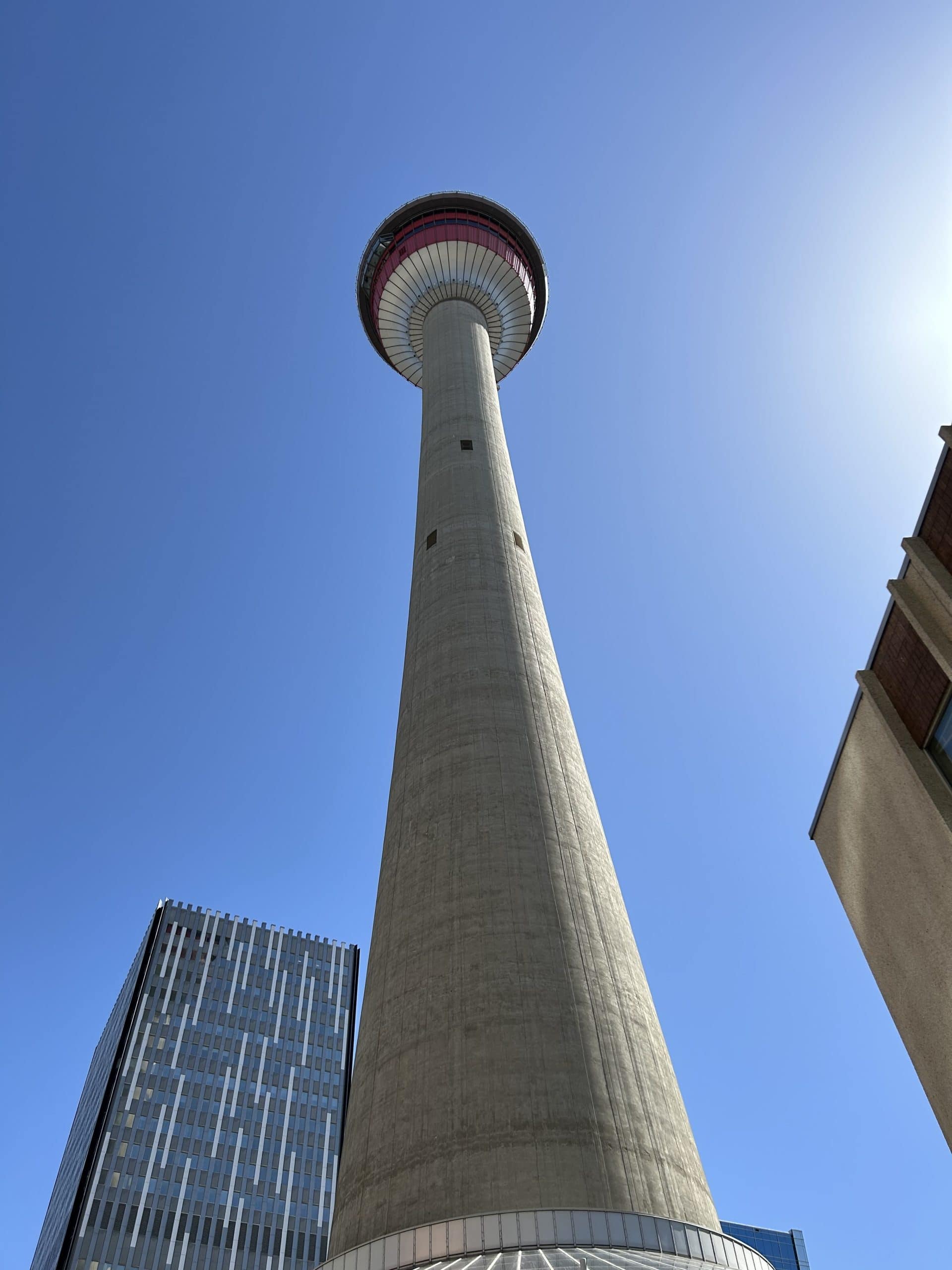 Looking up at the Calgary Tower with a clear blue sky behind it.