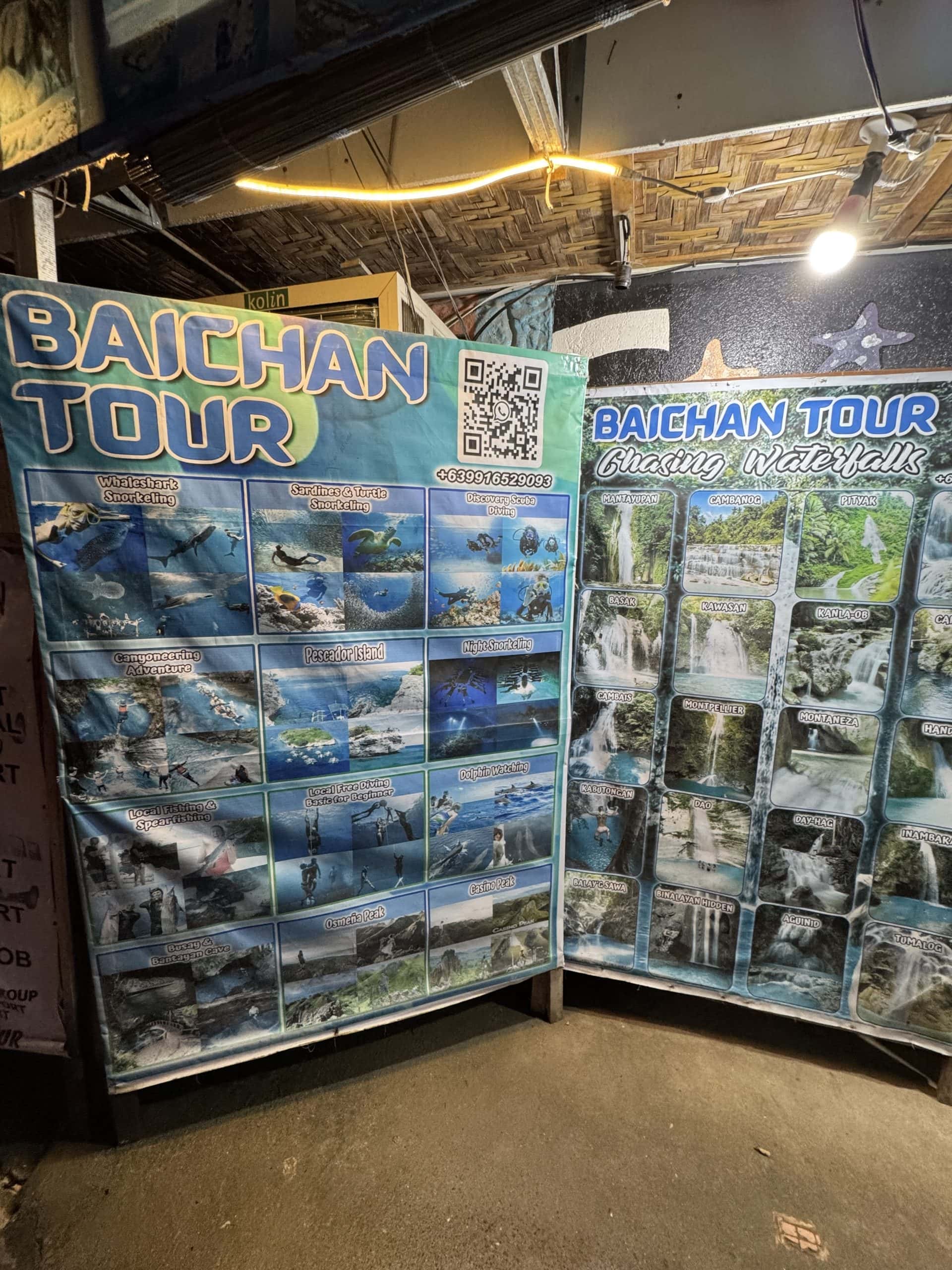 Tour booth display for Baichan Tour in Moalboal, Cebu, advertising canyoneering, snorkeling, island hopping, and waterfall tours in the Philippines