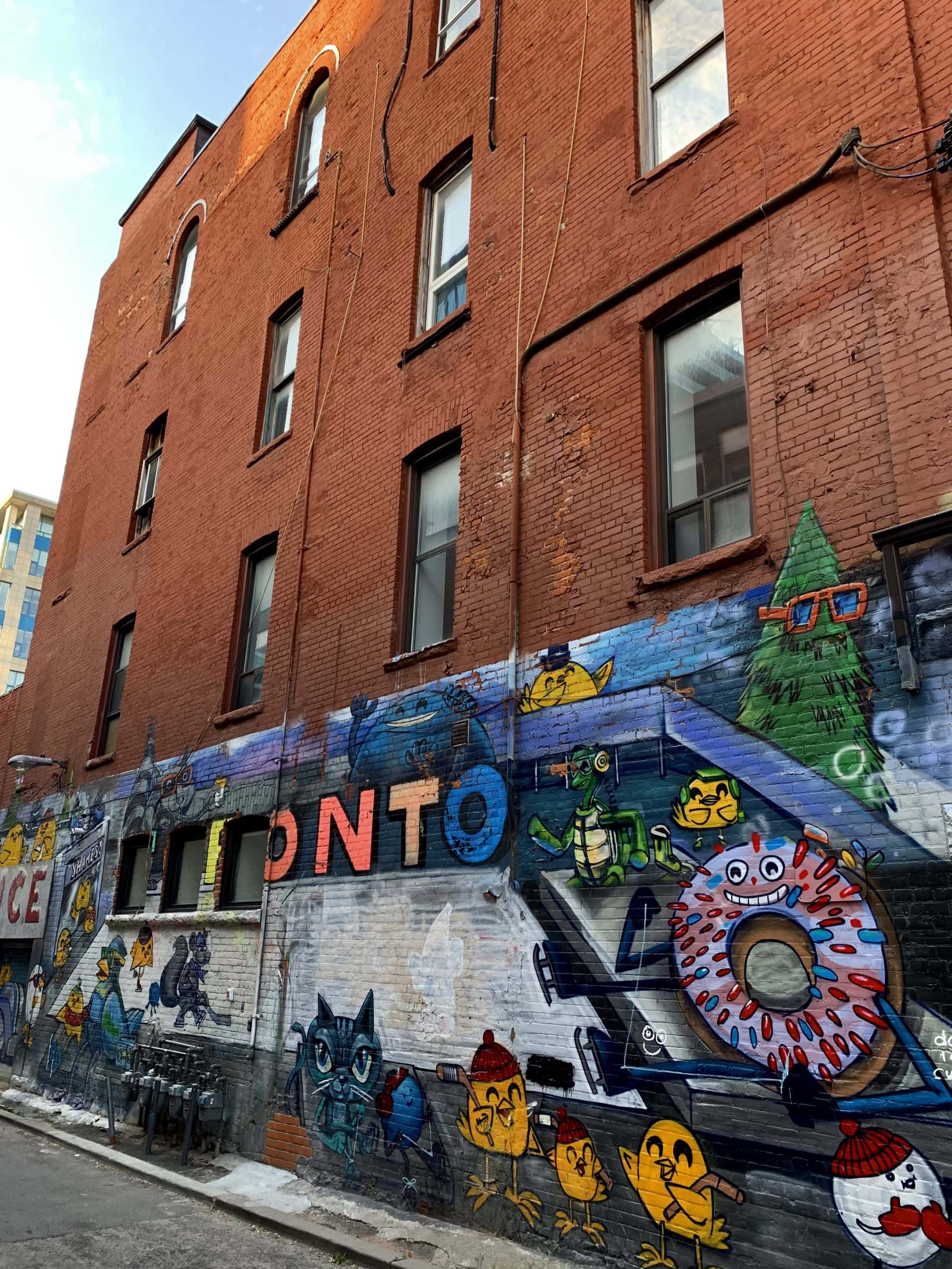 vibrant street scene in Kensington Market filled with murals and eclectic shops