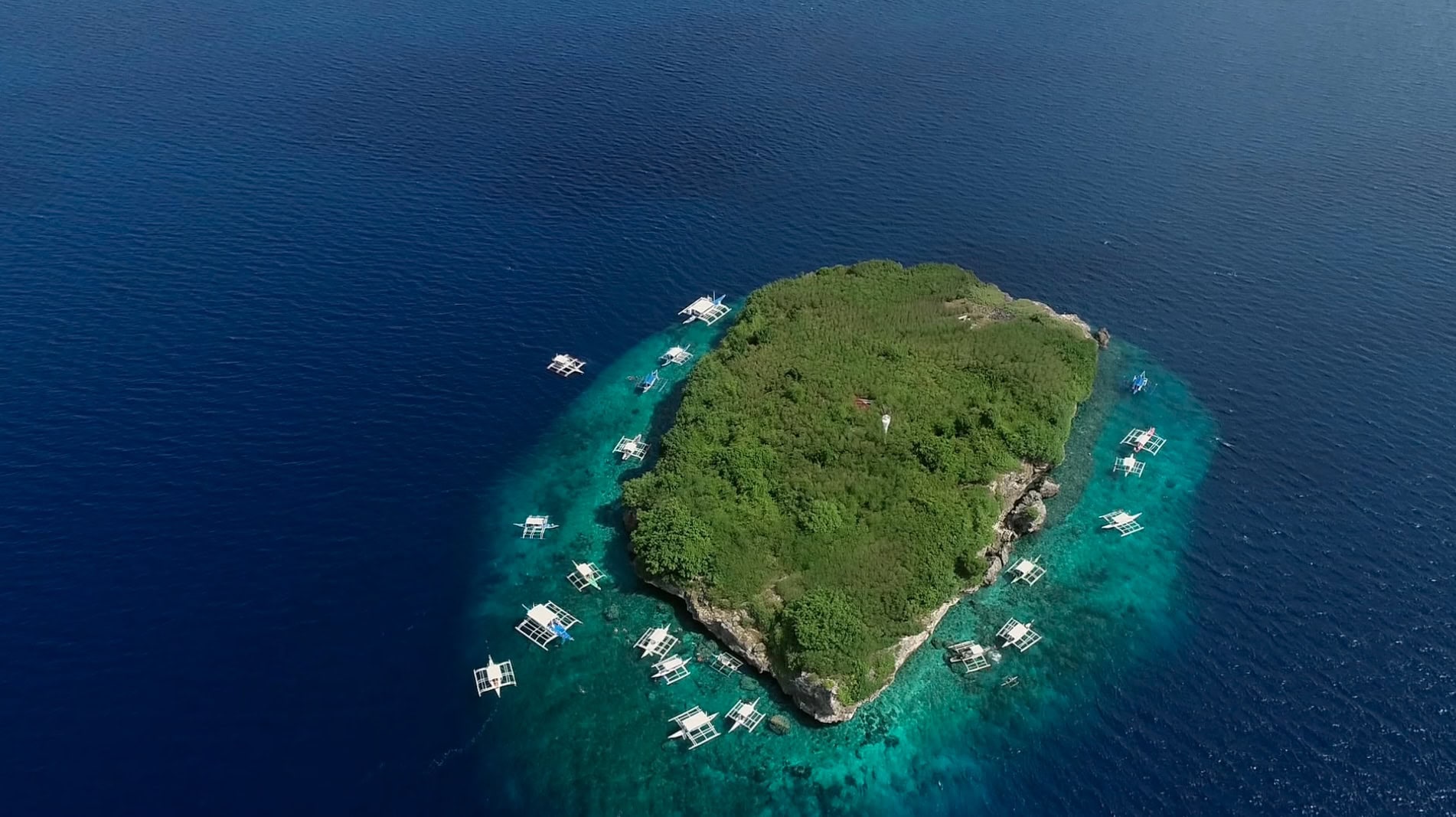 Aerial view of dive boats surrounding Pescador Island, one of the top scuba diving sites in Cebu for walls and marine life.