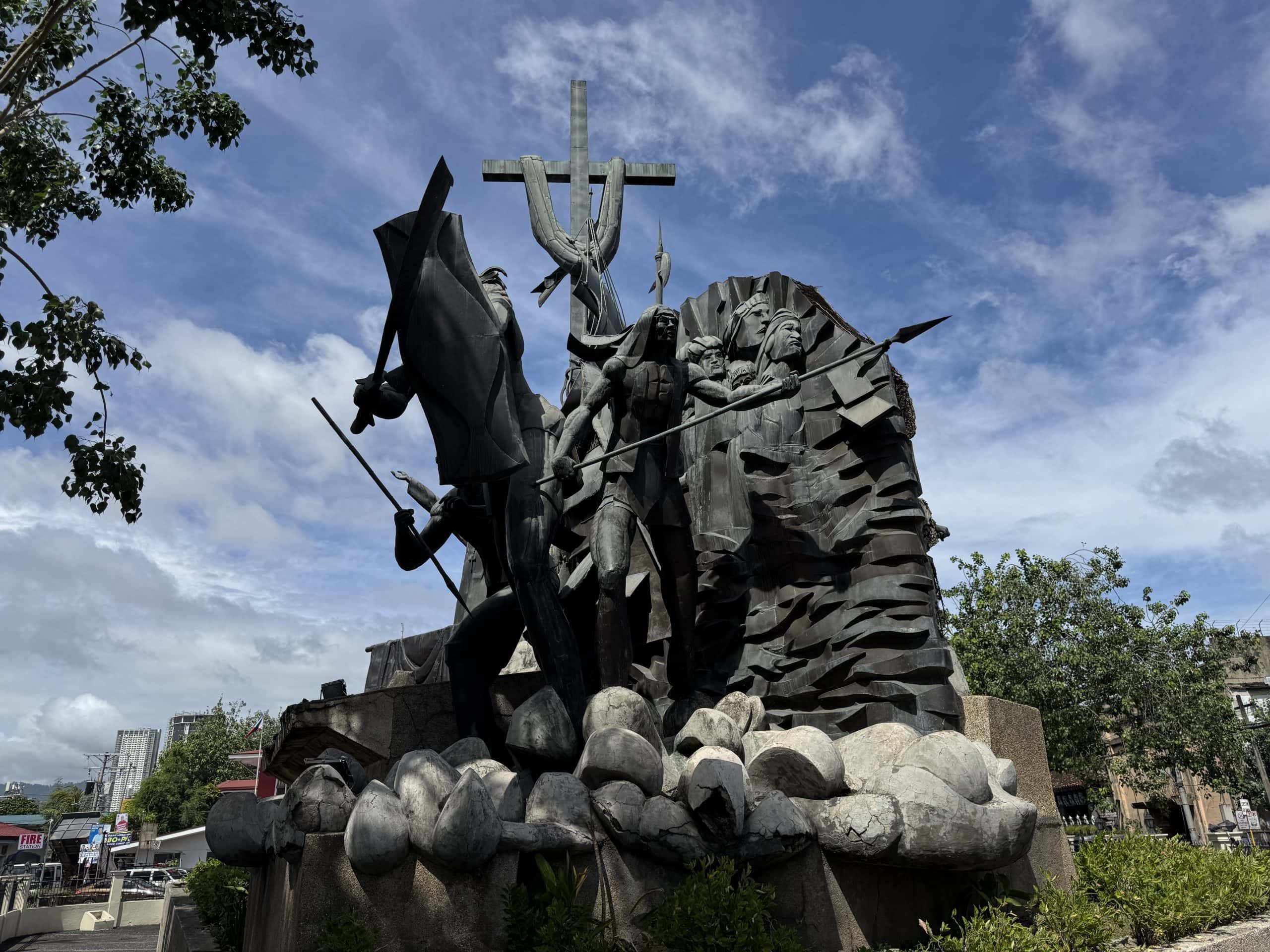 The Heritage of Cebu Monument, a dramatic sculpture depicting key moments in Cebu’s history, featuring Spanish conquistadors, religious icons, and cultural figures against a striking backdrop.