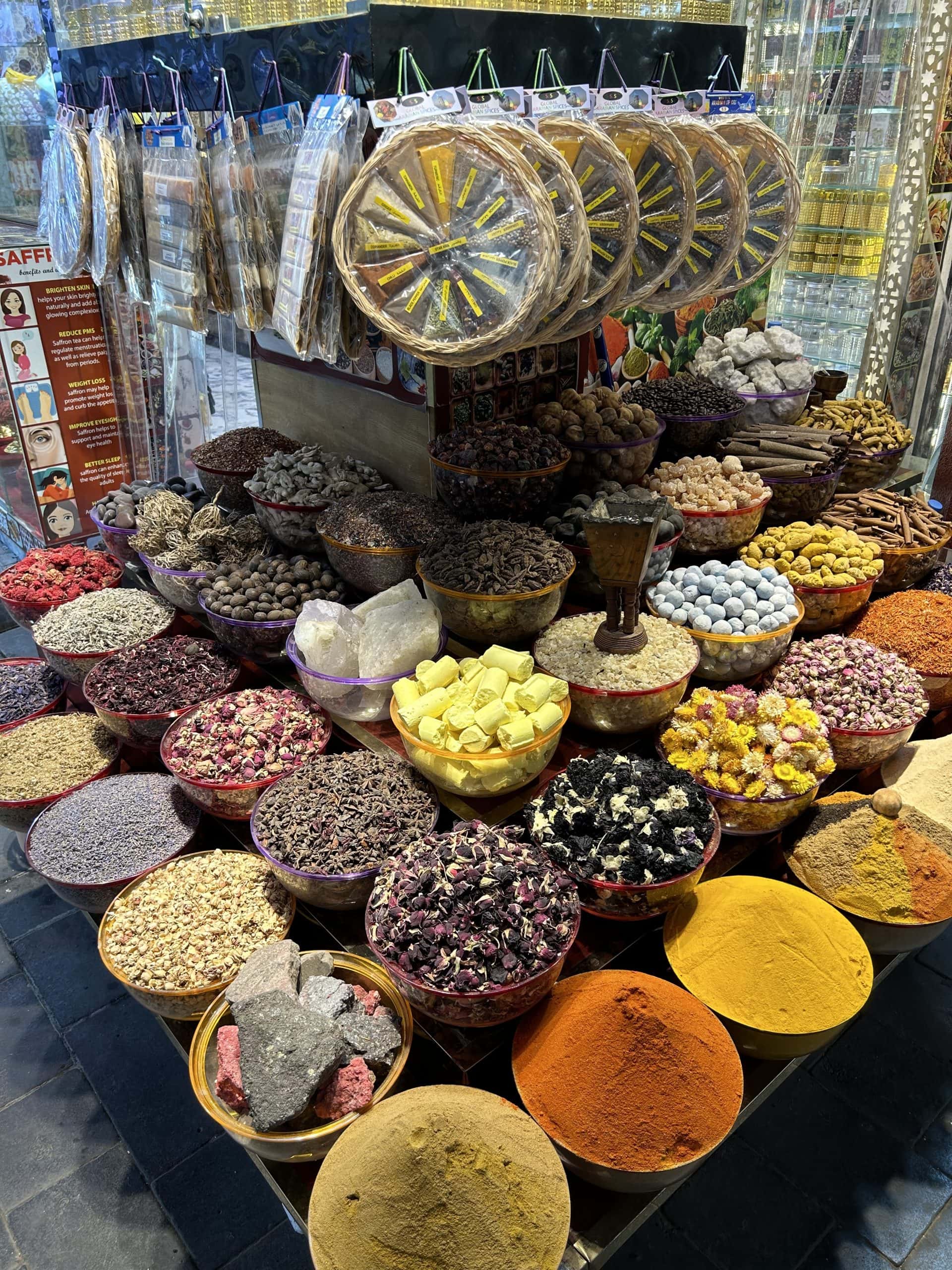 Colorful display of spices, herbs, and dried flowers at Dubai’s Spice Souk, showcasing the vibrant aromas and traditional market culture of the city.