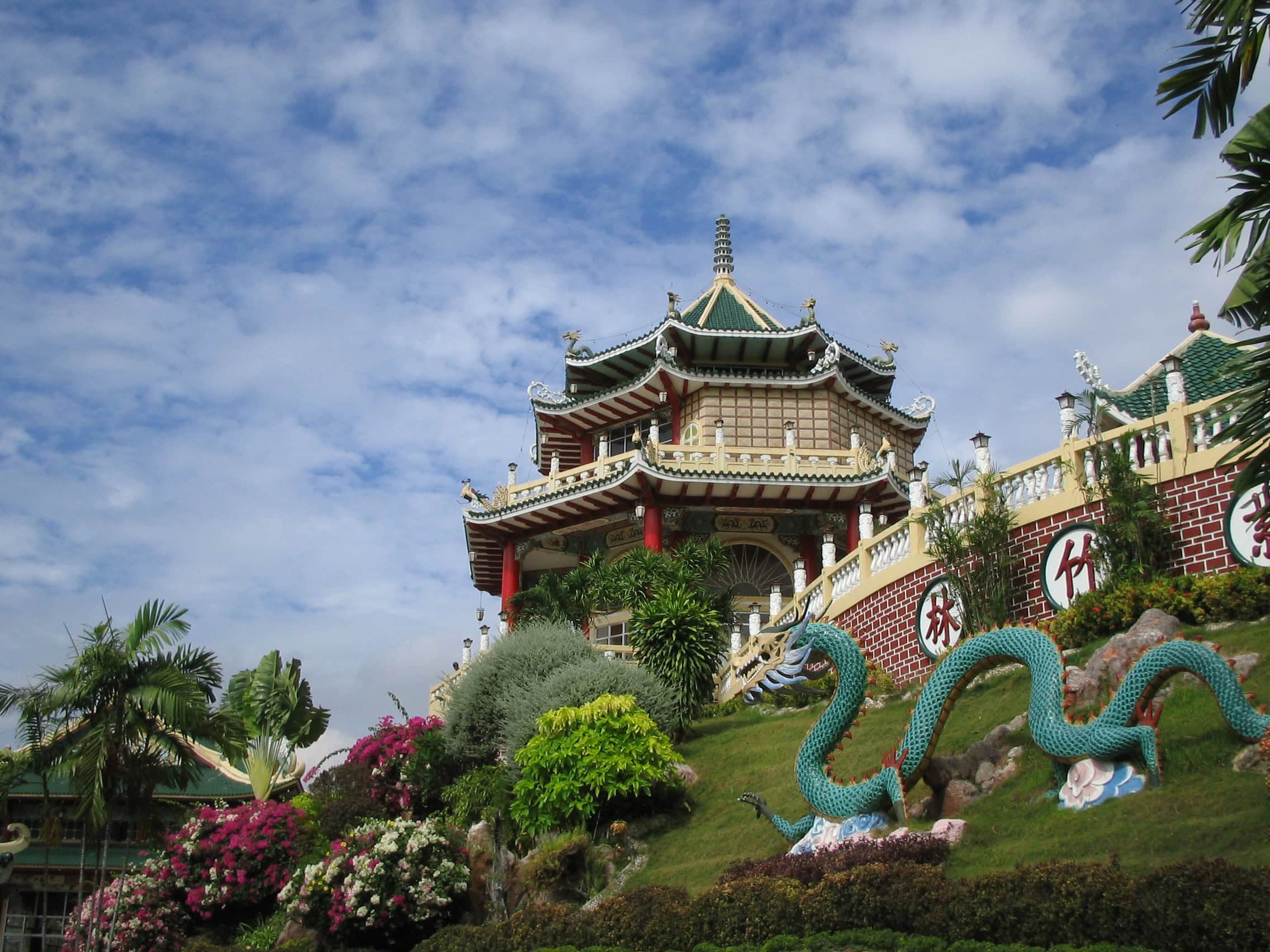 The Taoist Temple in Cebu City, a colourful landmark featuring traditional Chinese architecture, dragon statues, and lush gardens set against a vibrant hillside backdrop.
