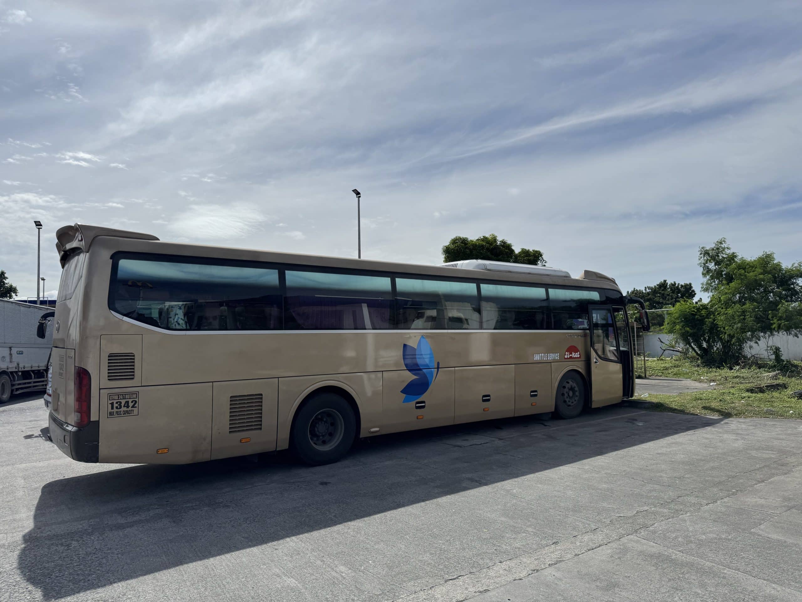 Sikat shuttle bus stopped at a highway rest area between Manila and Batangas, where passengers take a short break before continuing to Puerto Galera.
