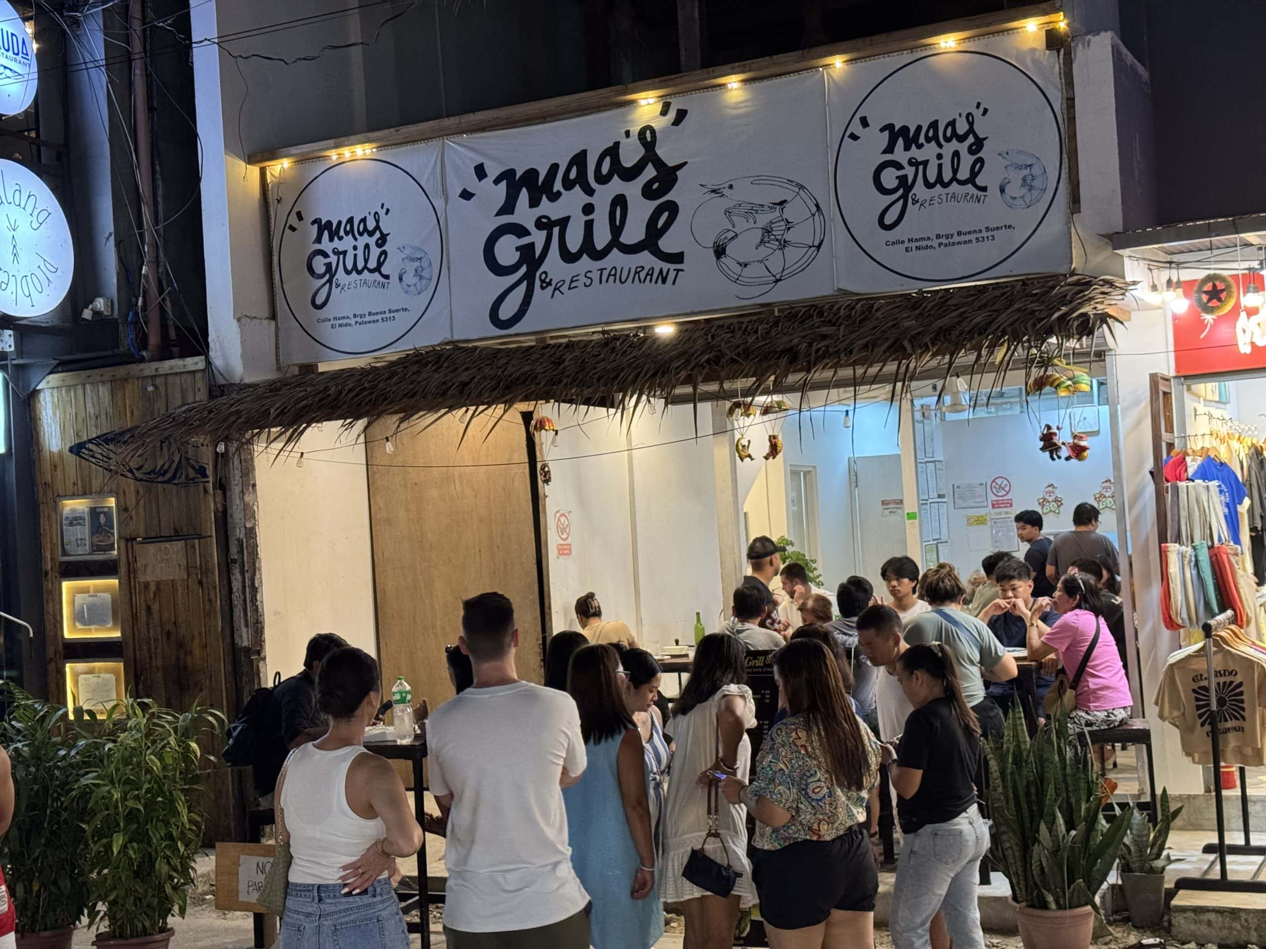 Crowded restaurant in El Nido, Philippines with people waiting in line to eat.
