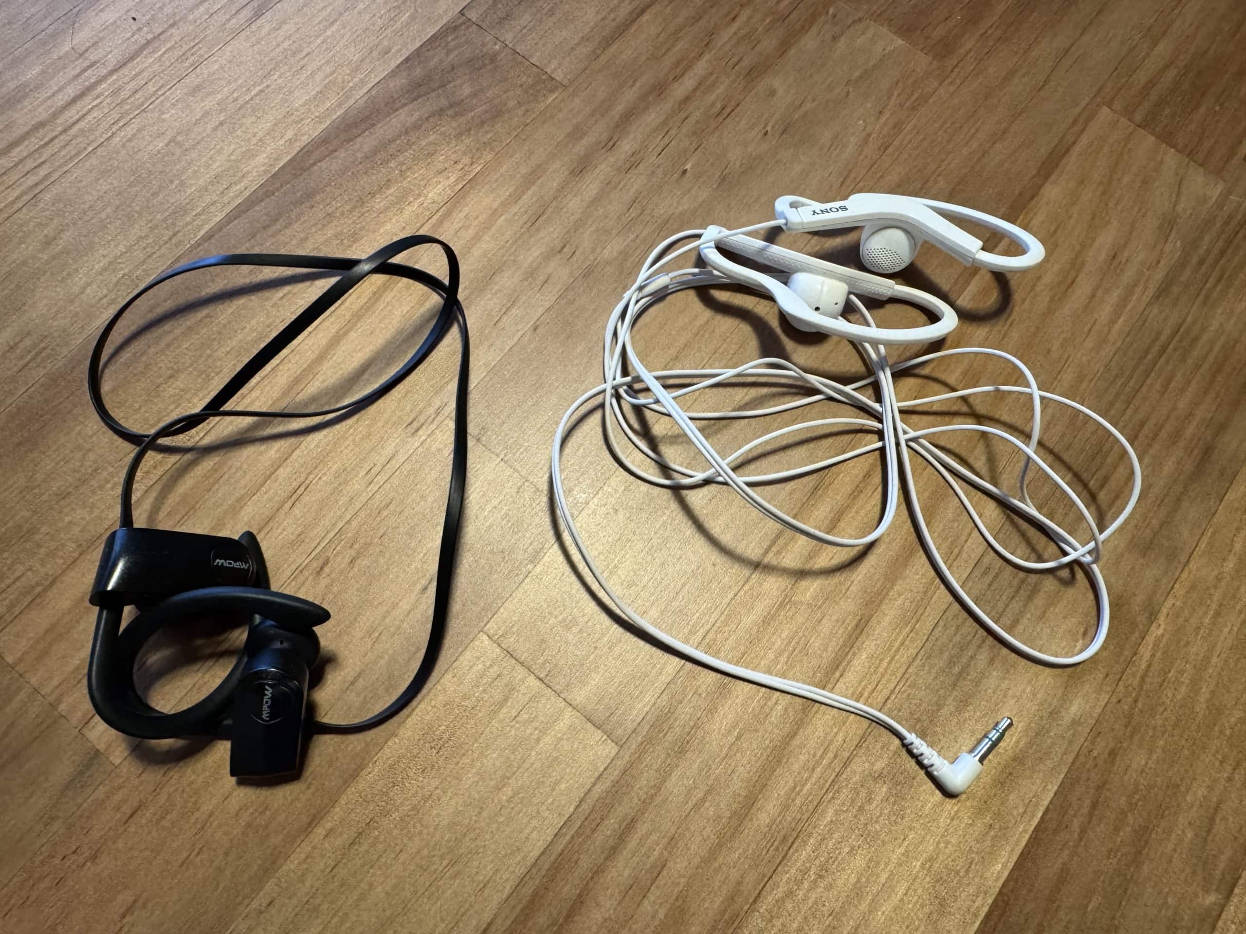 Wired and wireless headphones used for flights and travel, including a wired headset for plane audio and wireless earbuds for everyday use.