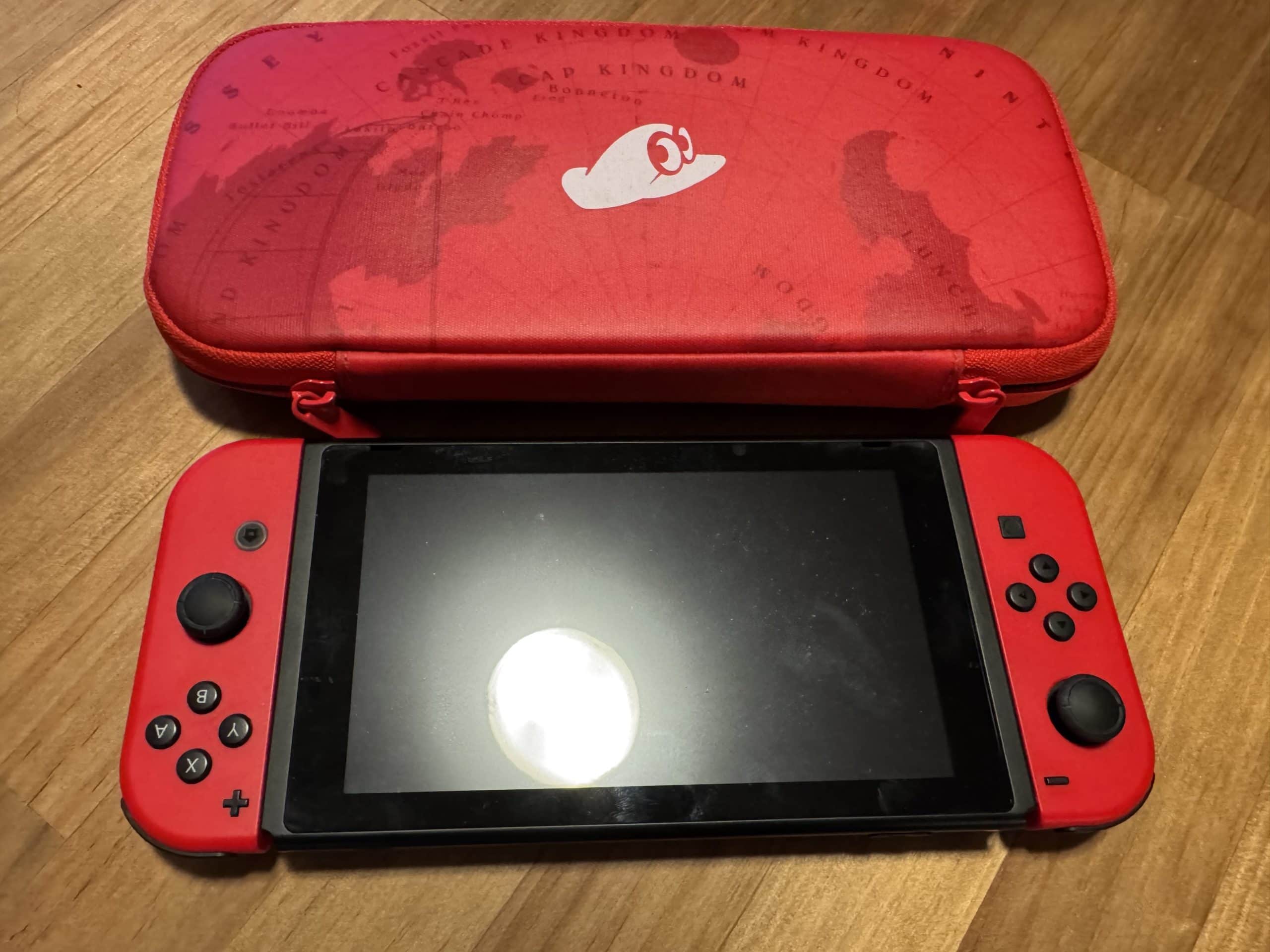 Nintendo Switch with red controllers and travel case, packed for entertainment on long flights and travel days.