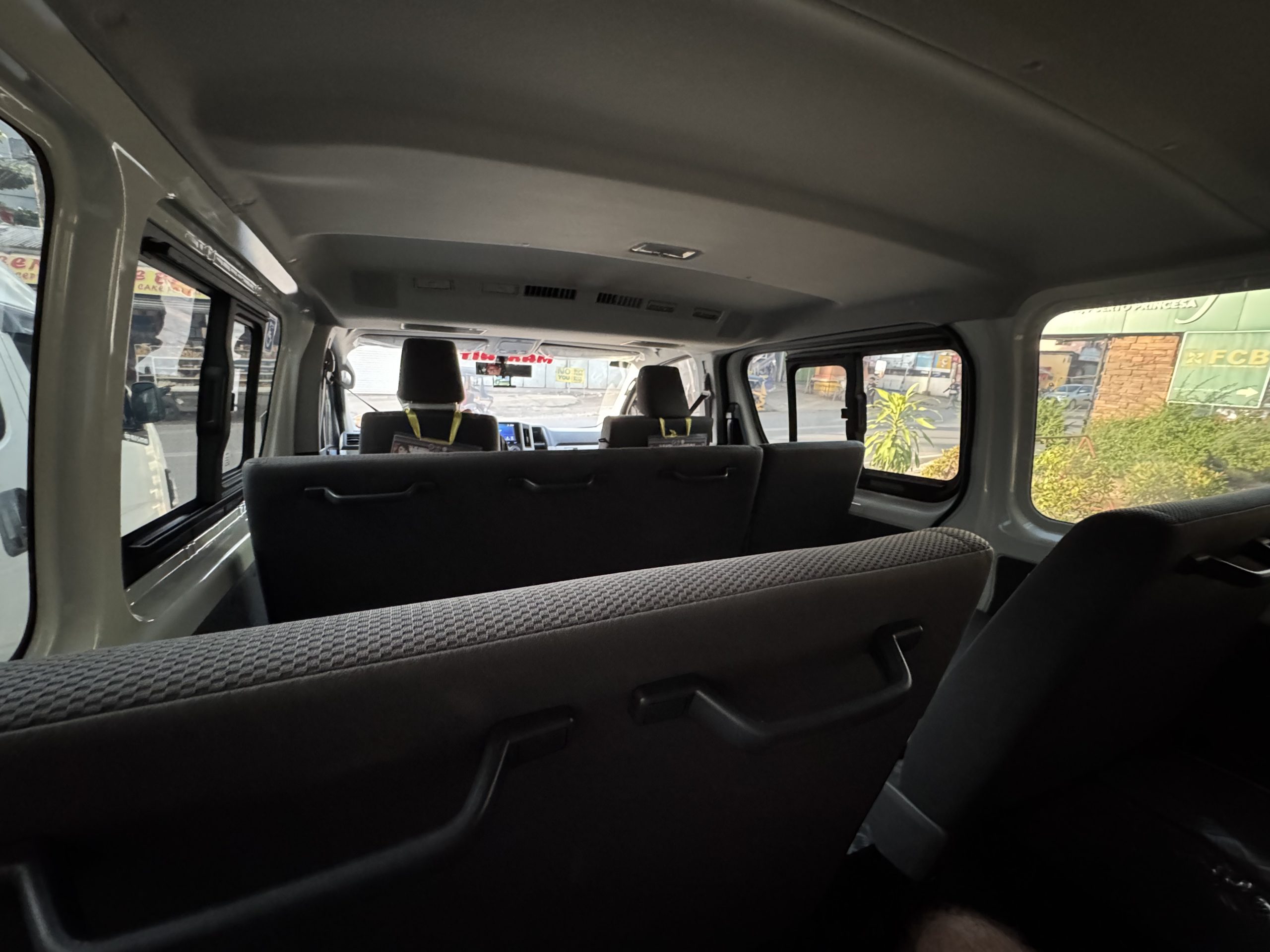 Interior of a modern shared van in Puerto Princesa with bench style seating, air conditioning, and limited legroom, showing the typical setup for van transfers to El Nido in Palawan.