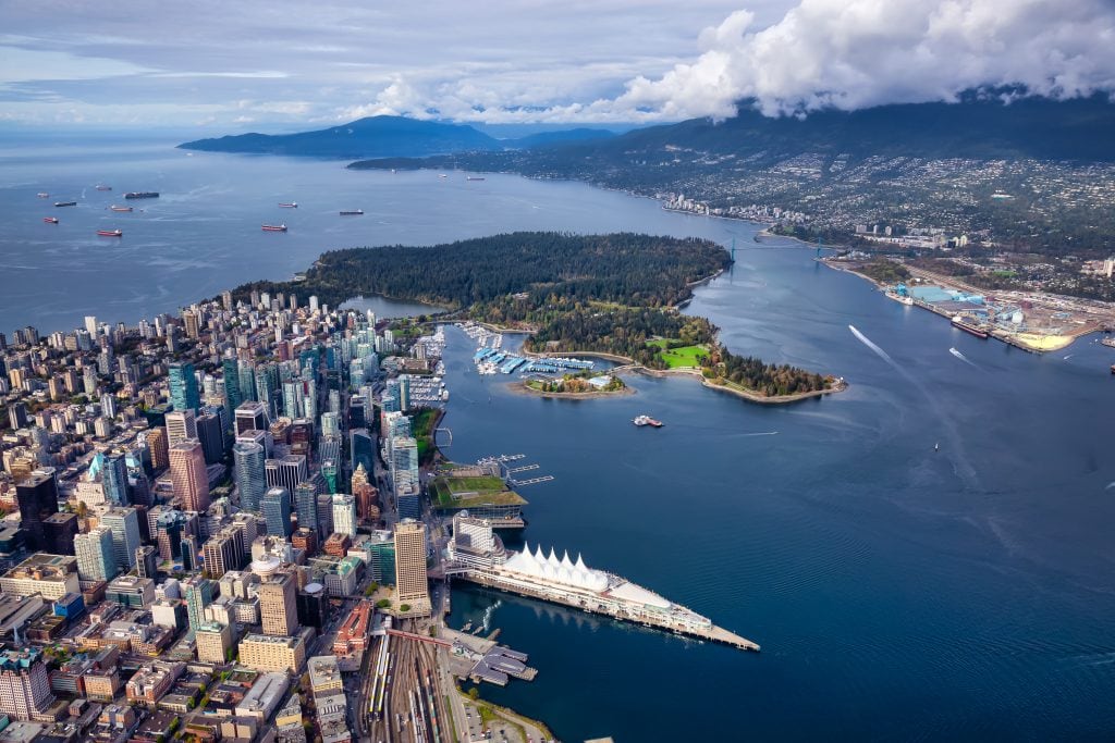 Aerial view of downtown Vancouver, Canada Place, Stanley Park, Burrard Inlet, and the Lions Gate Bridge with the North Shore Mountains in the background