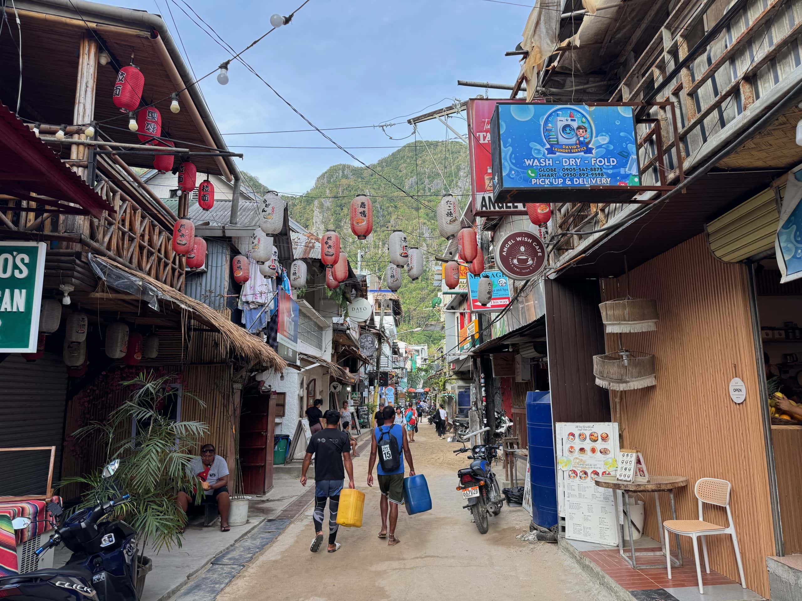 Busy street in El Nido town lined with restaurants, shops, and lanterns, showing the lively and walkable atmosphere of the area