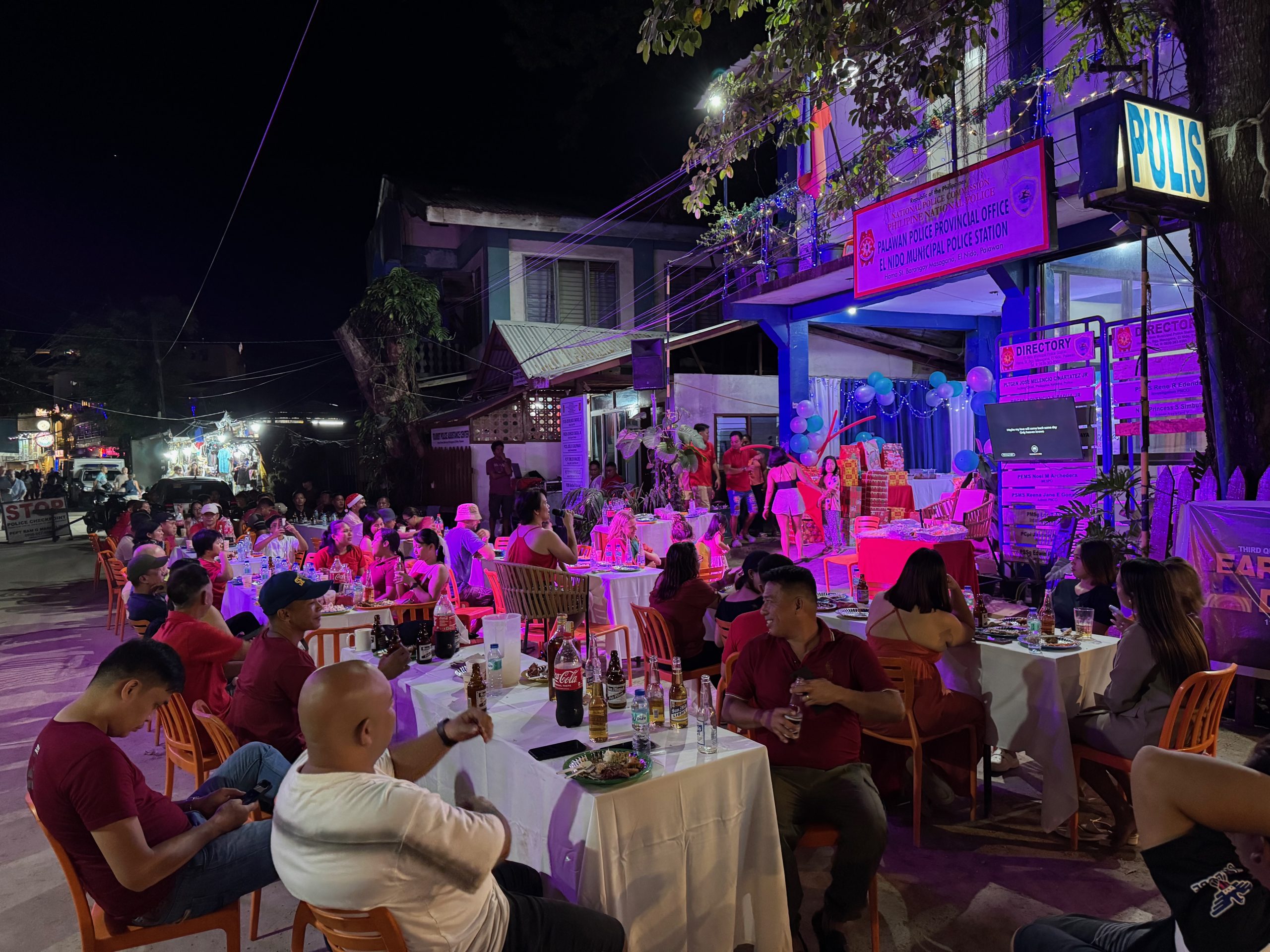 Local street dining scene in El Nido at night with seafood, drinks, and a lively social atmosphere among locals and travellers