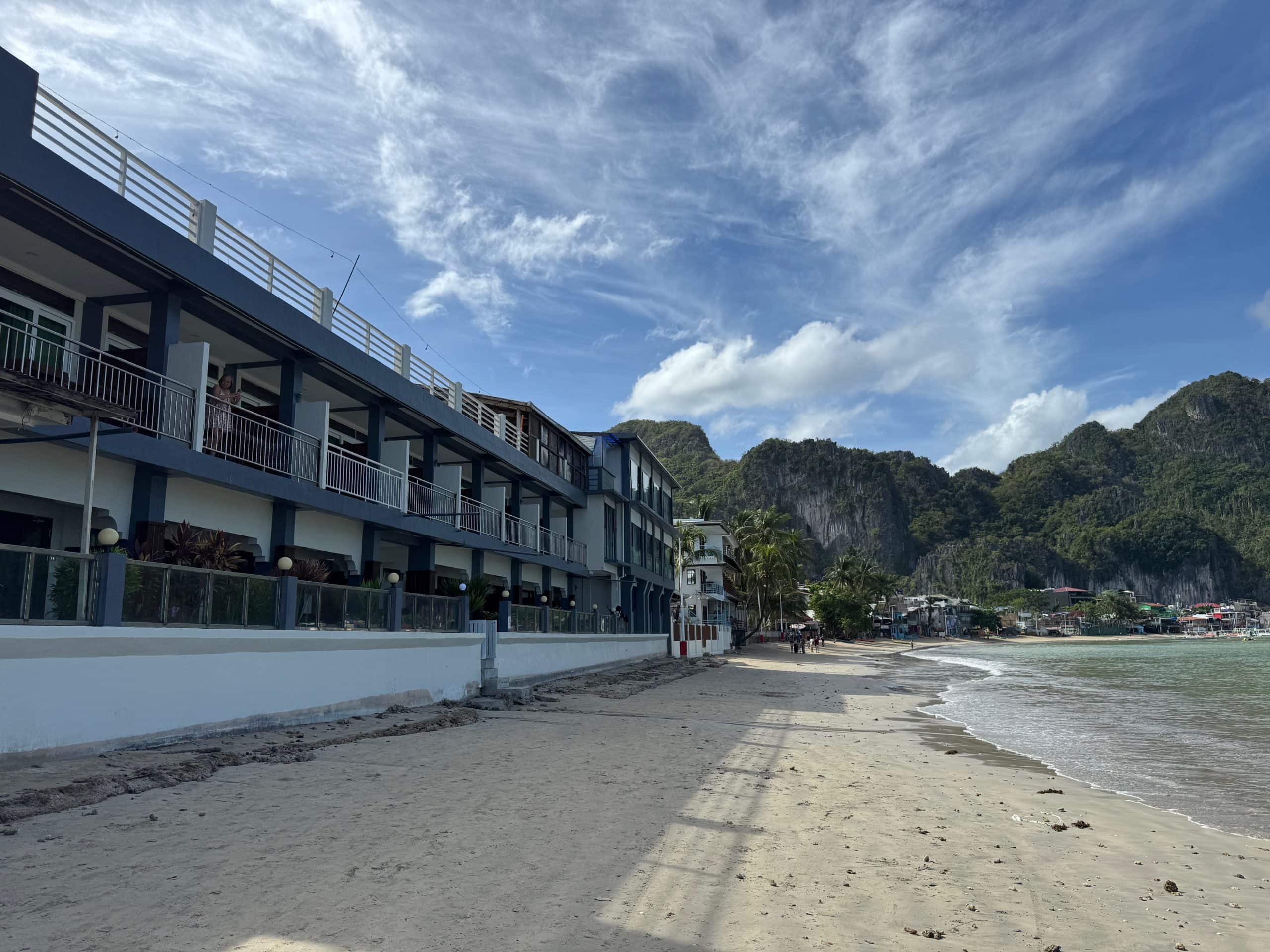 El Nido Beach Hotel on the beachfront in Palawan Philippines with views of the ocean and surrounding limestone cliffs.