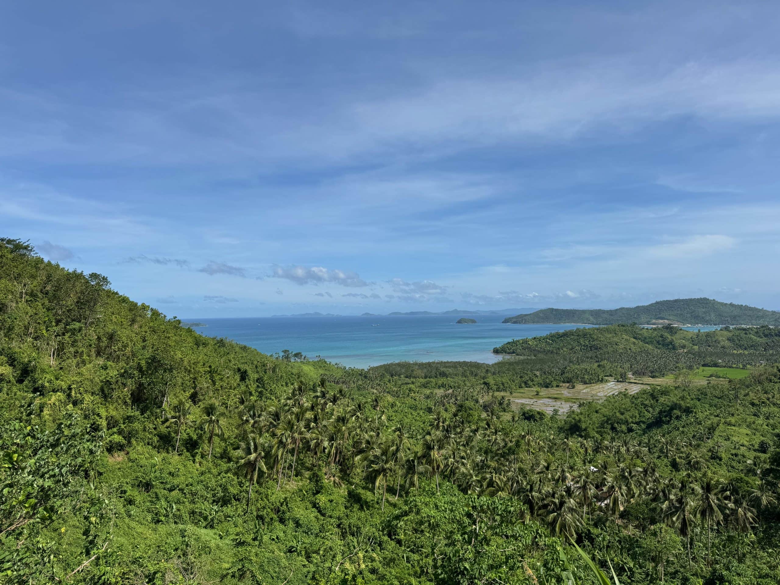 Scenic coastal viewpoint on the scooter ride from El Nido to Sibaltan, a route known for its lush jungle hills and access to manta ray diving spots