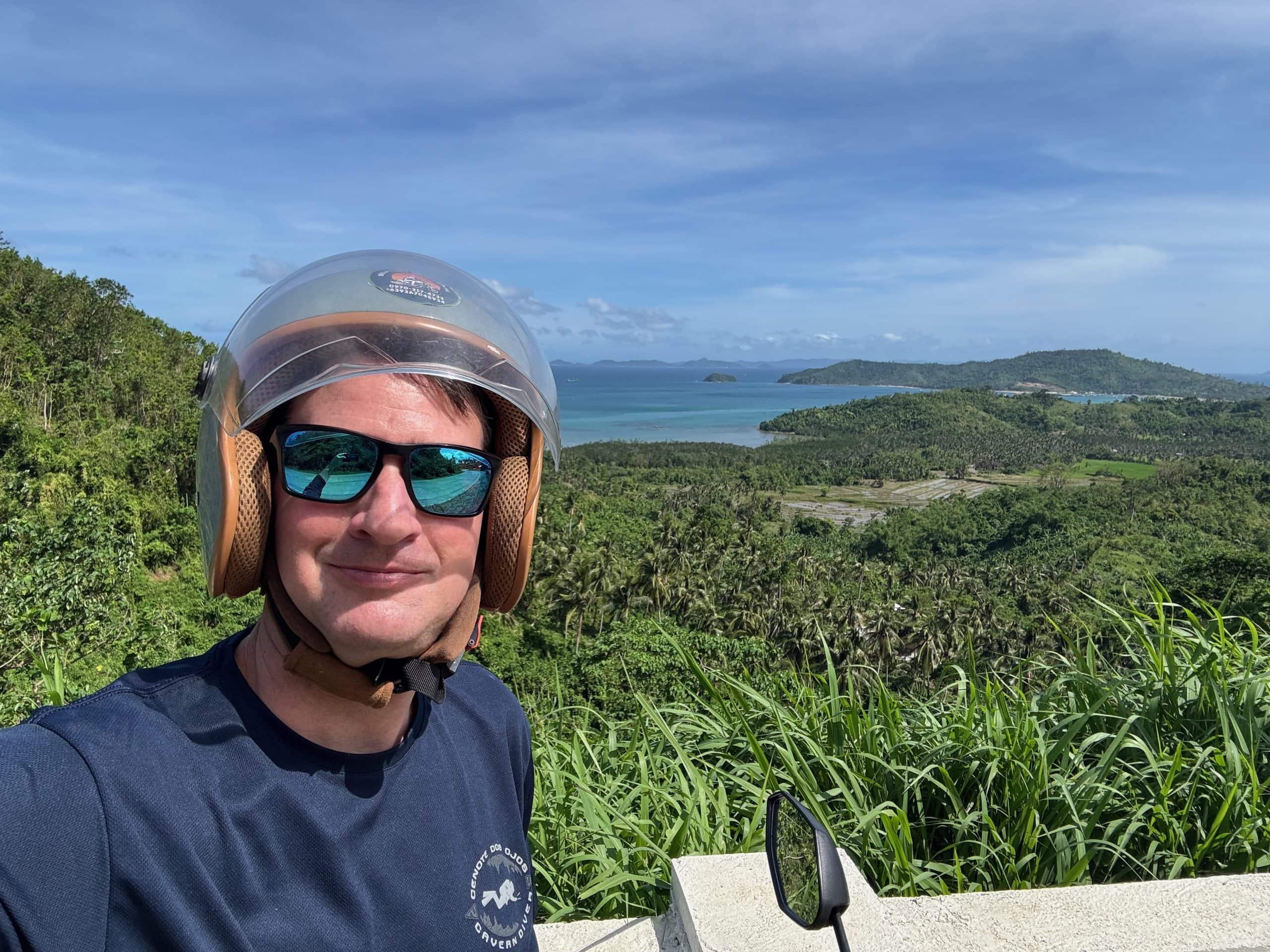 Scenic viewpoint during a scooter ride from El Nido overlooking lush jungle, coastline, and turquoise waters in Palawan Philippines