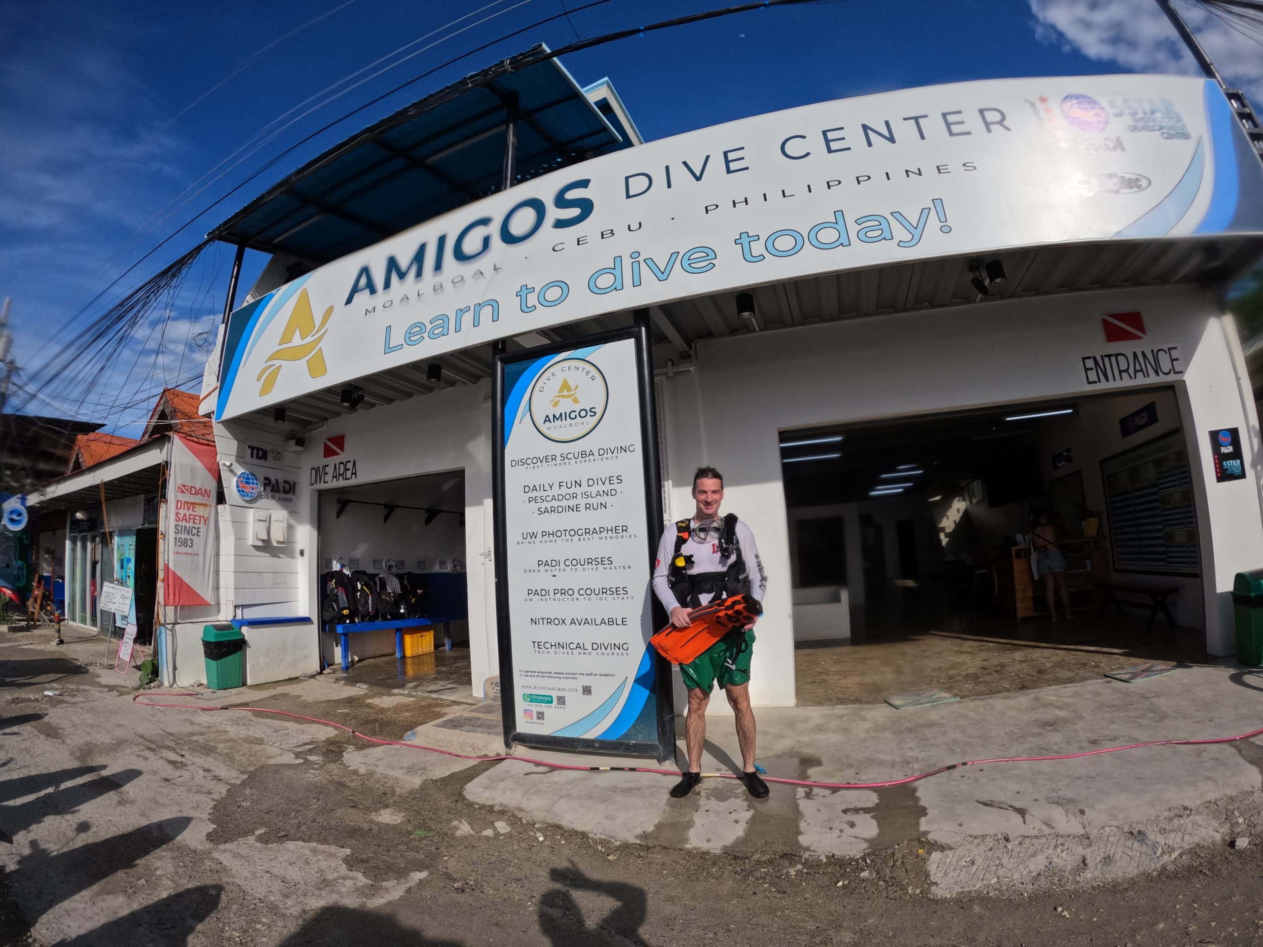 Scuba diver outside Amigos Dive Center in Moalboal, Cebu, Philippines, one of the popular dive shops offering easy shore dives to the famous sardine run near Panagsama Beach.