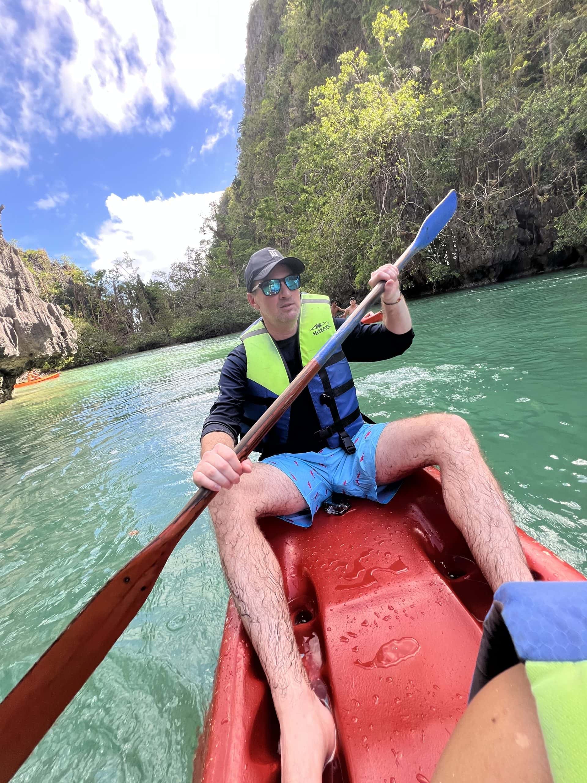 Kayaking through Big Lagoon during El Nido Tour A in Palawan Philippines surrounded by turquoise water and towering limestone cliffs.
