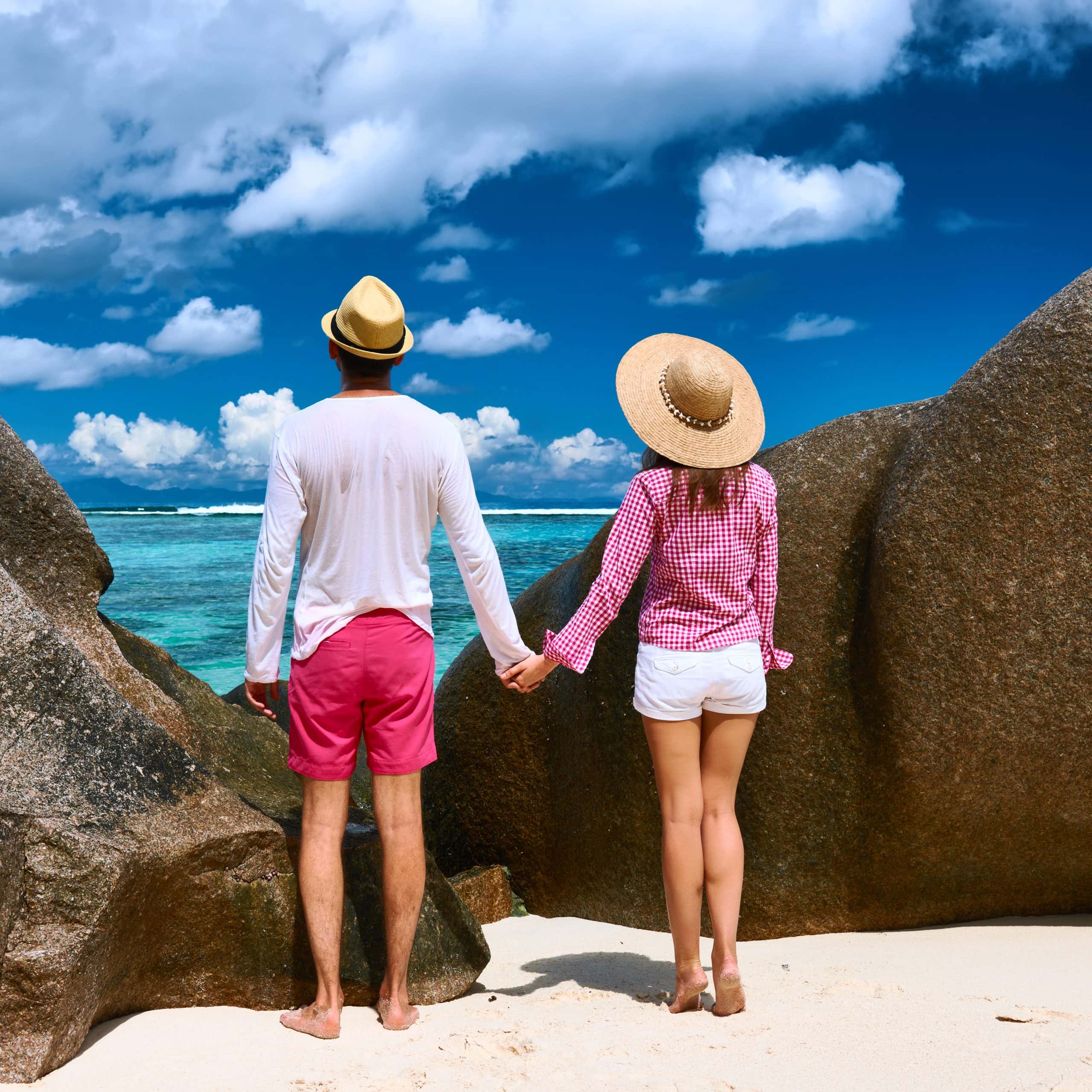 Couple holding hands on a tropical beach during vacation