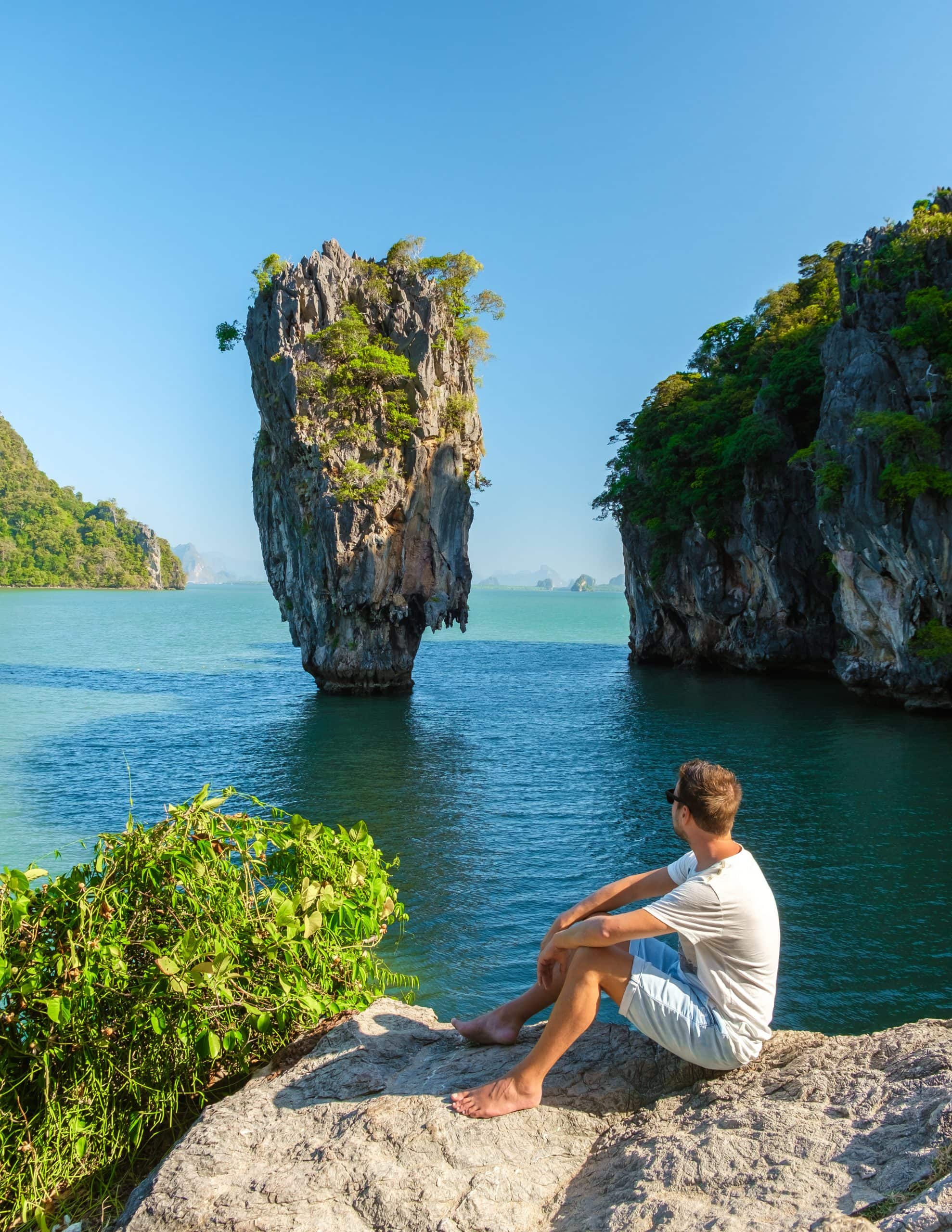 Solo traveller overlooking tropical limestone islands in Thailand