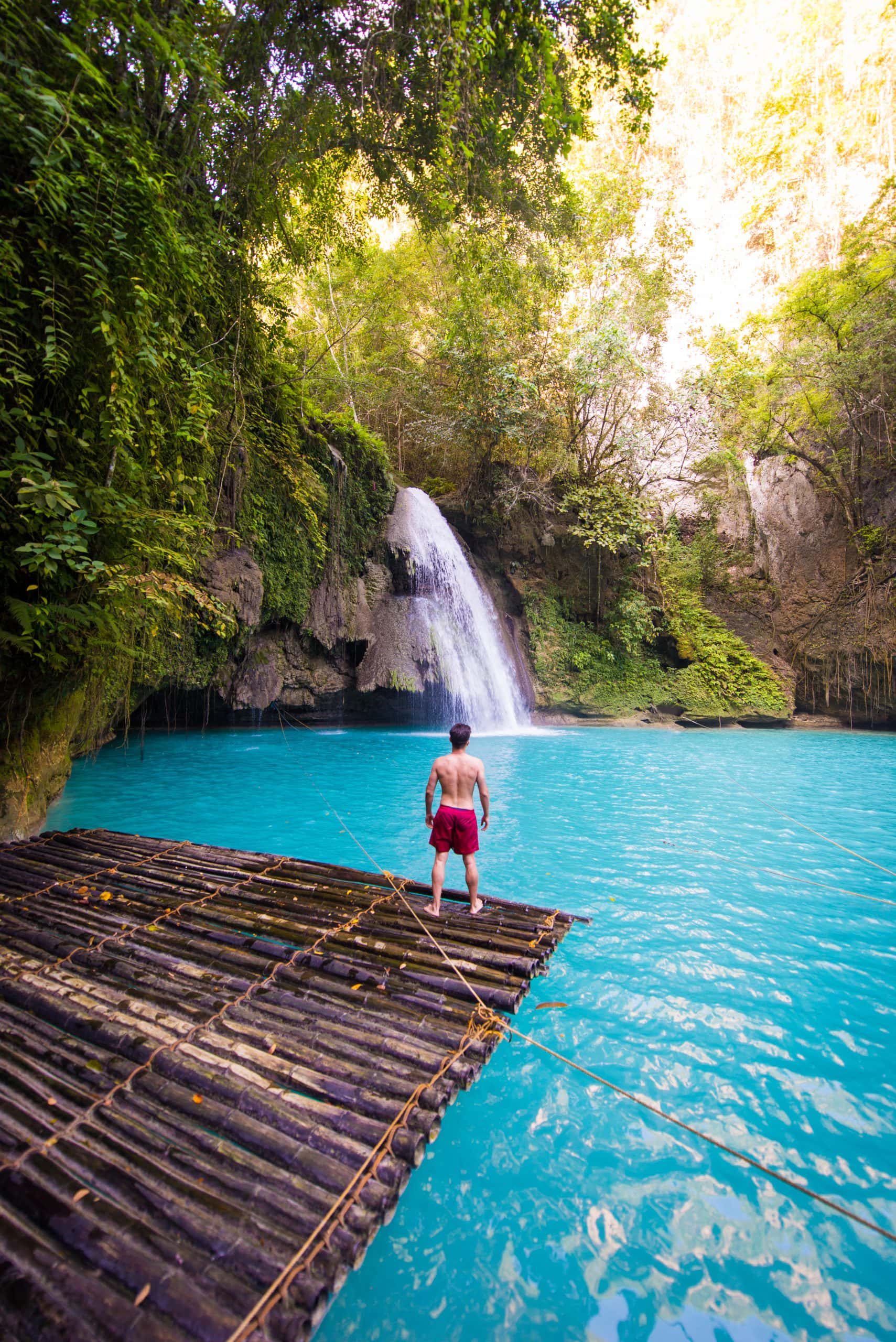 Traveller standing beside a tropical waterfall in Cebu, Philippines