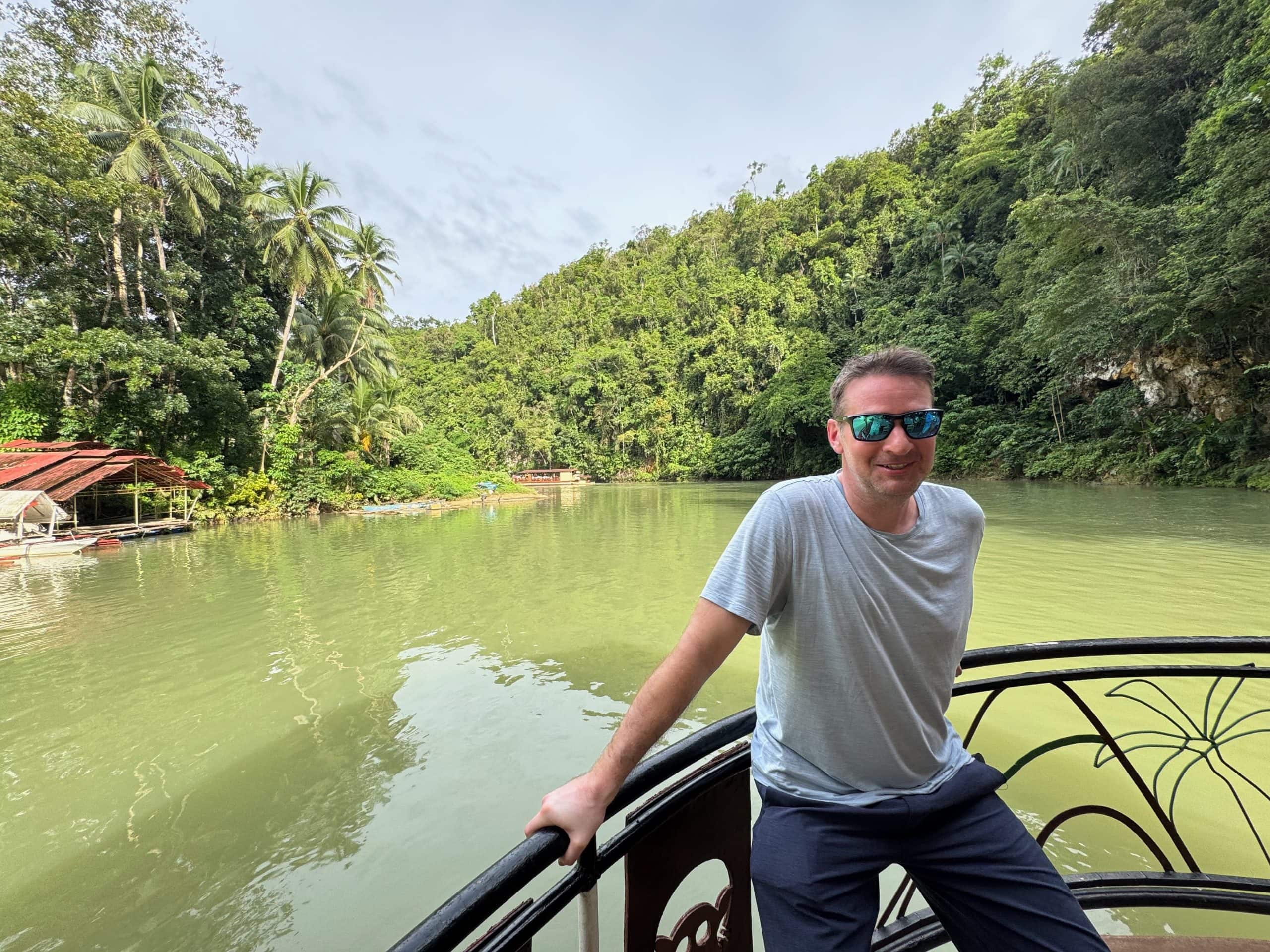 Ryan travelling along the Loboc River in Bohol, surrounded by the lush tropical scenery of the Philippines.