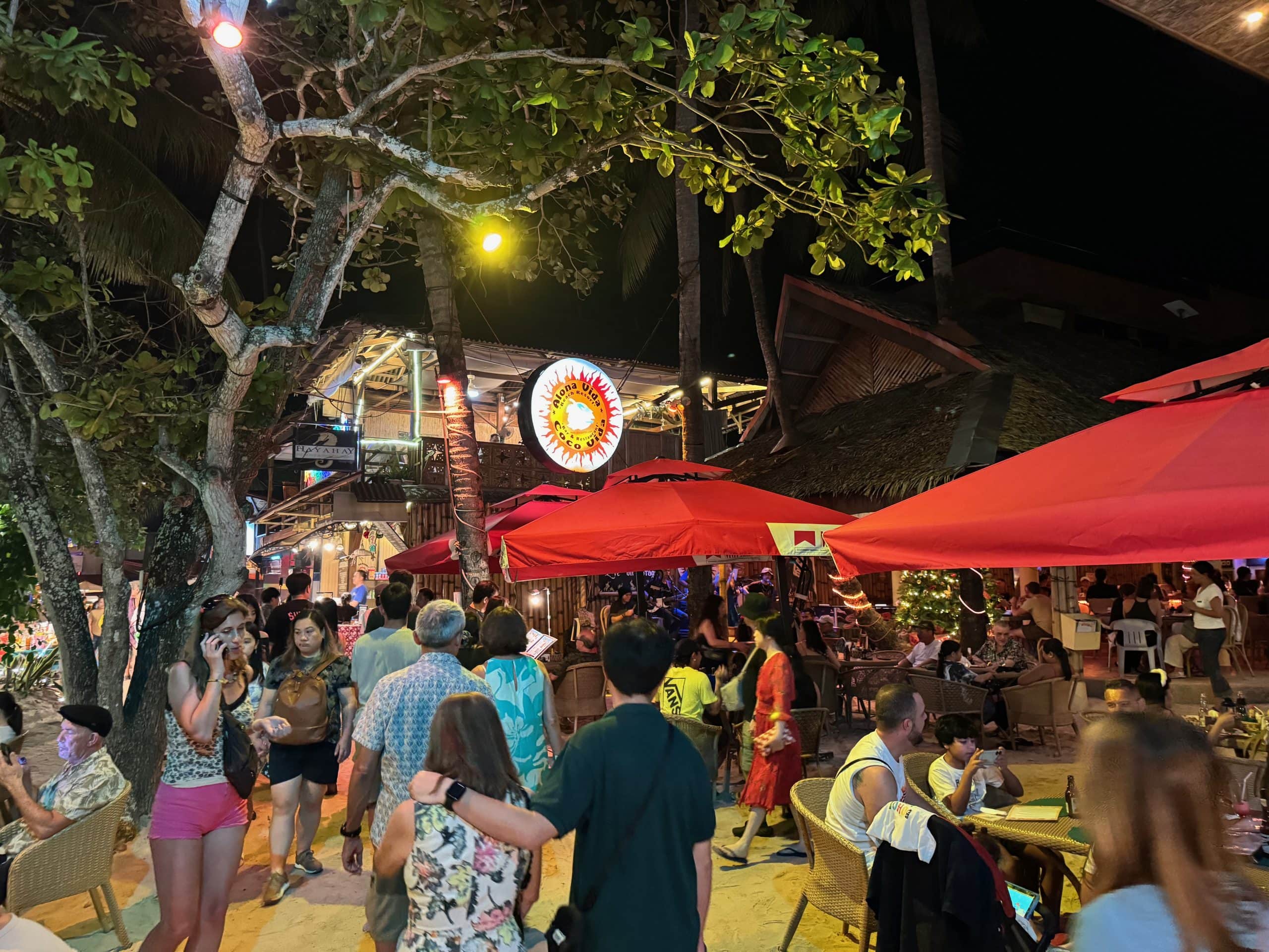 Nightlife along Alona Beach in Panglao, Bohol, with beachfront bars, restaurants and crowds beside the water.