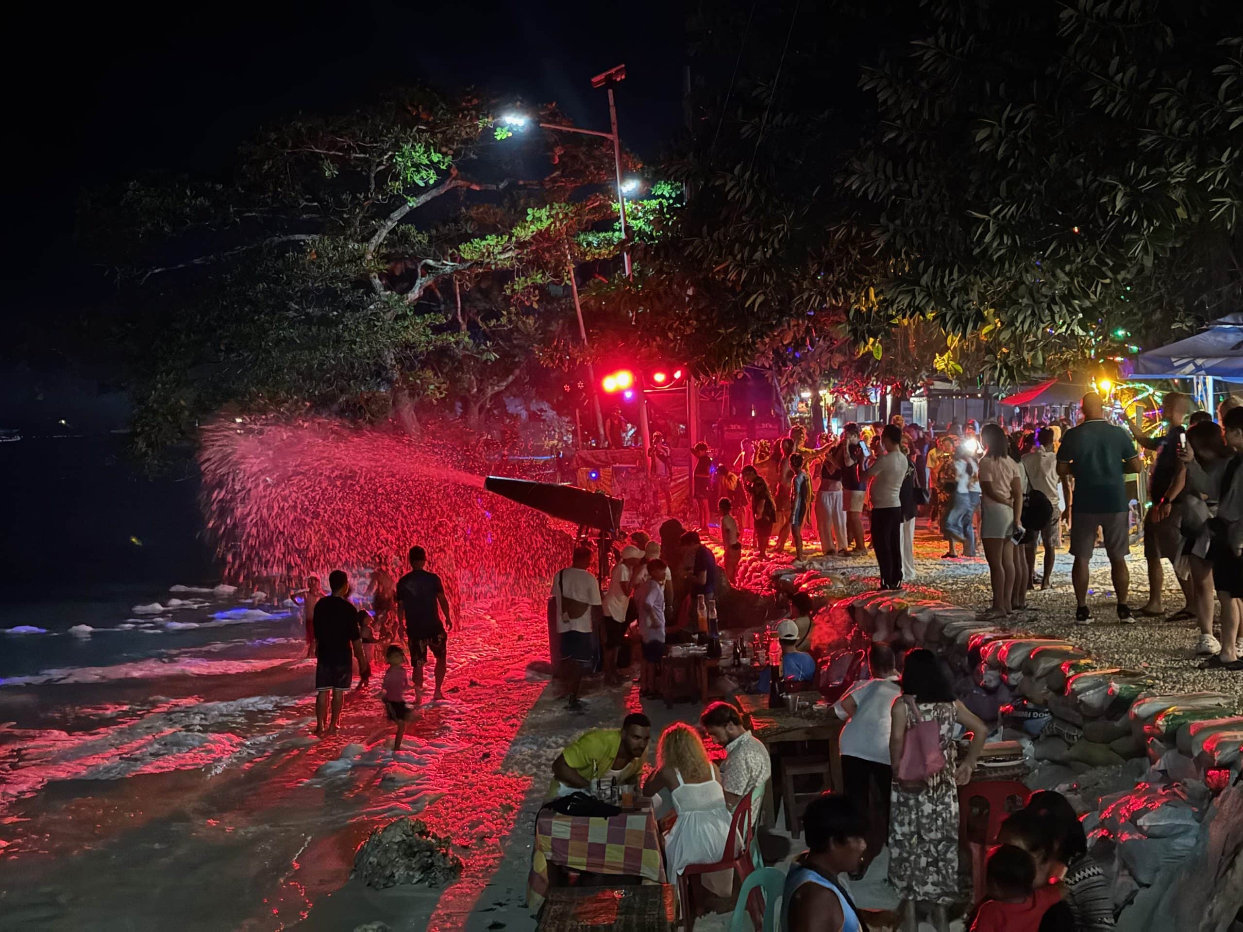 Busy evening scene at Alona Beach in Panglao, Bohol, with open-air restaurants, bars and visitors enjoying the nightlife.