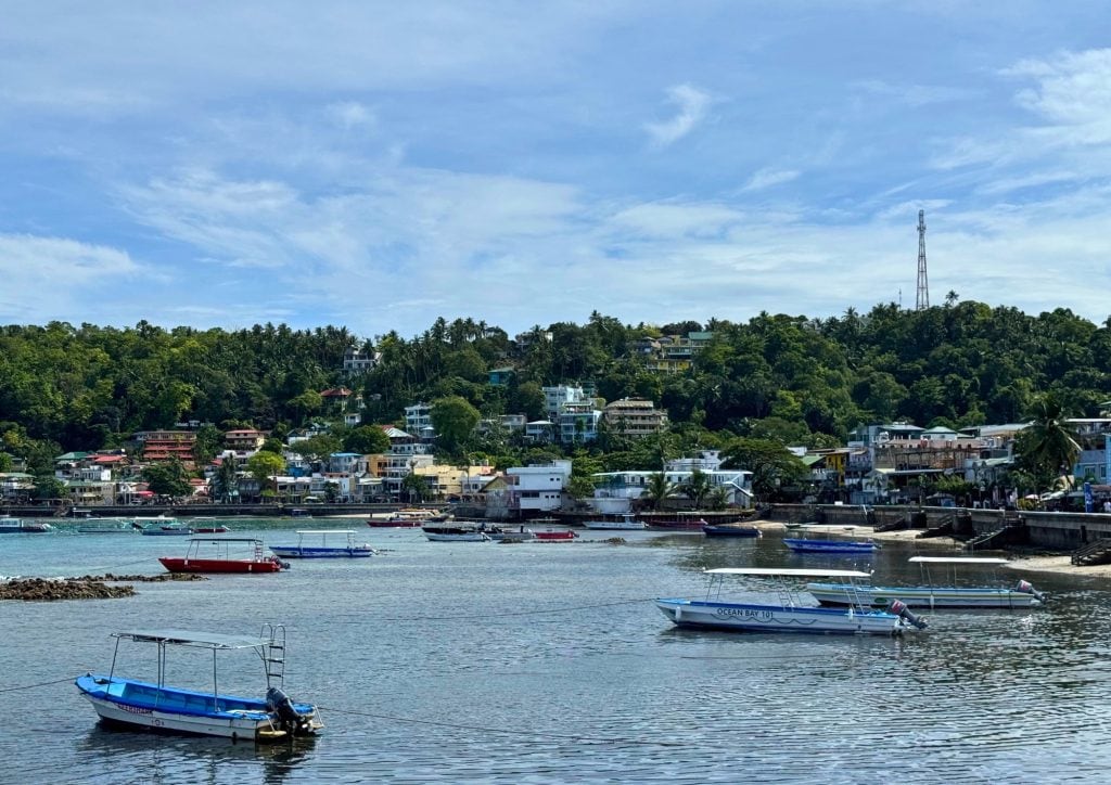 Waterfront view of Puerto Galera with boats anchored along the shoreline.