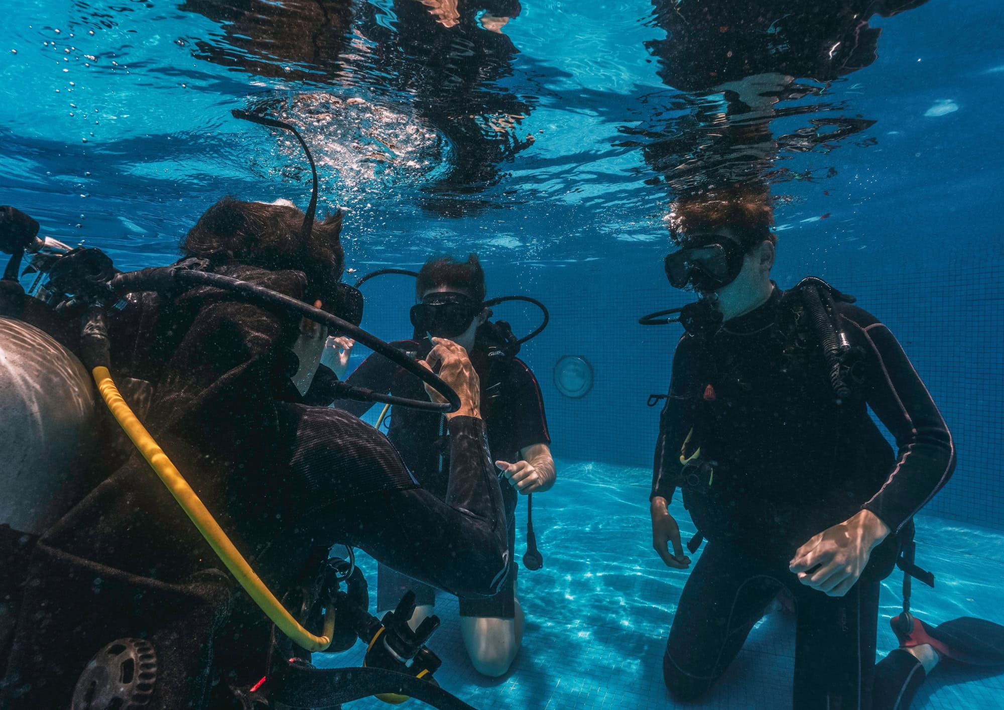 Scuba instructor guiding divers underwater during a training dive, representing scuba skills, certifications and dive education.