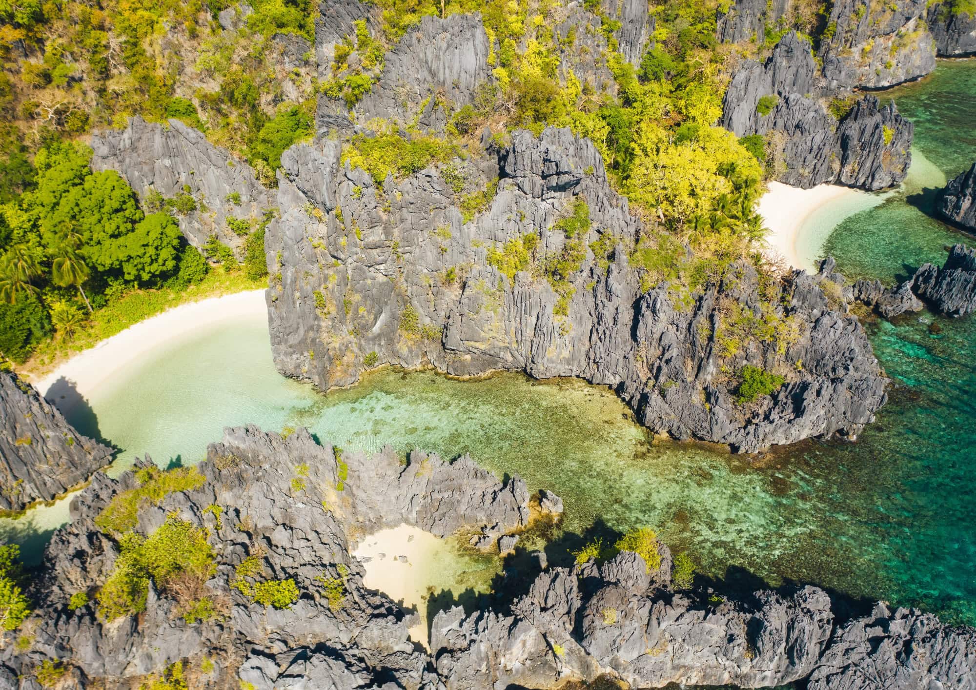 White sand beach nestled between limestone cliffs in El Nido, Palawan.