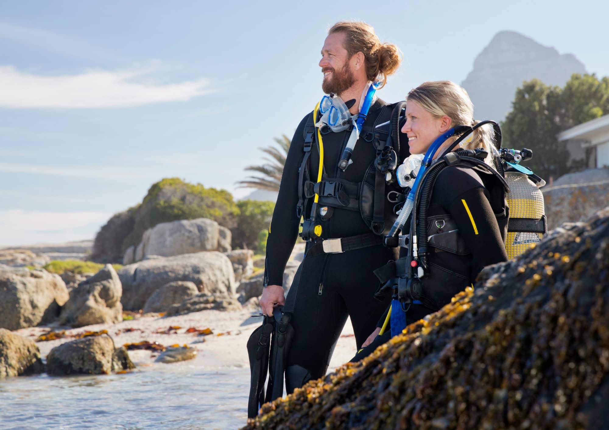 Two scuba divers preparing before a dive, representing dive safety, planning and travel insurance resources.