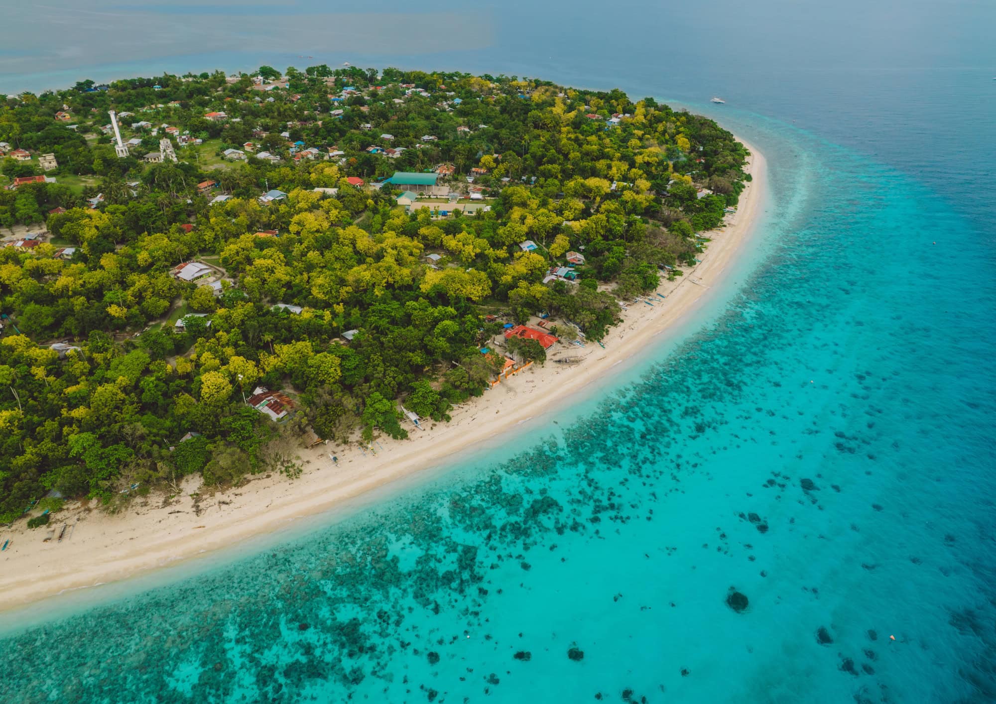 Aerial view of tropical islands in the Philippines surrounded by turquoise water, representing world class scuba diving destinations and island adventures.