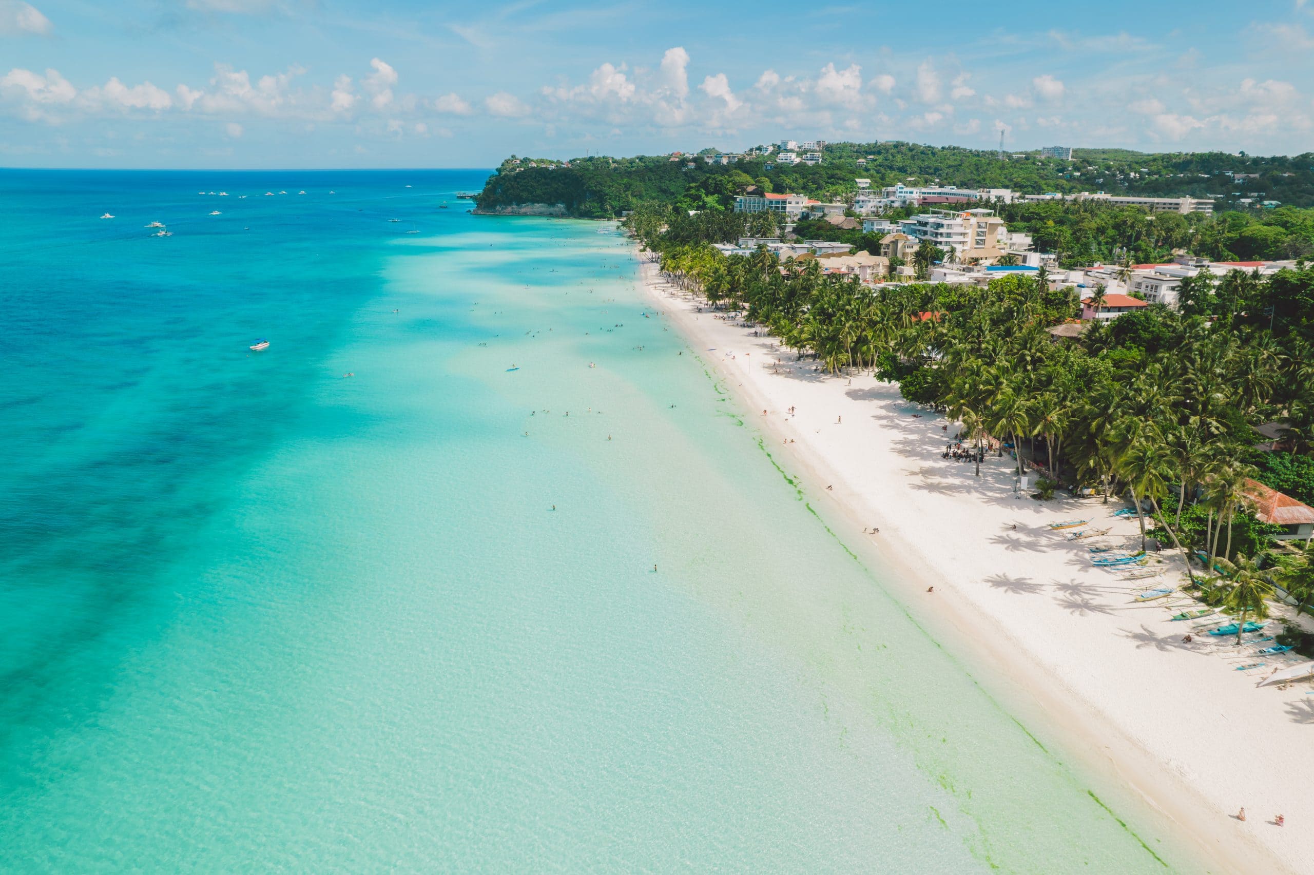 Aerial view of Boracay’s White Beach in the Philippines, with white sand, turquoise water, palm trees and beachfront resorts.