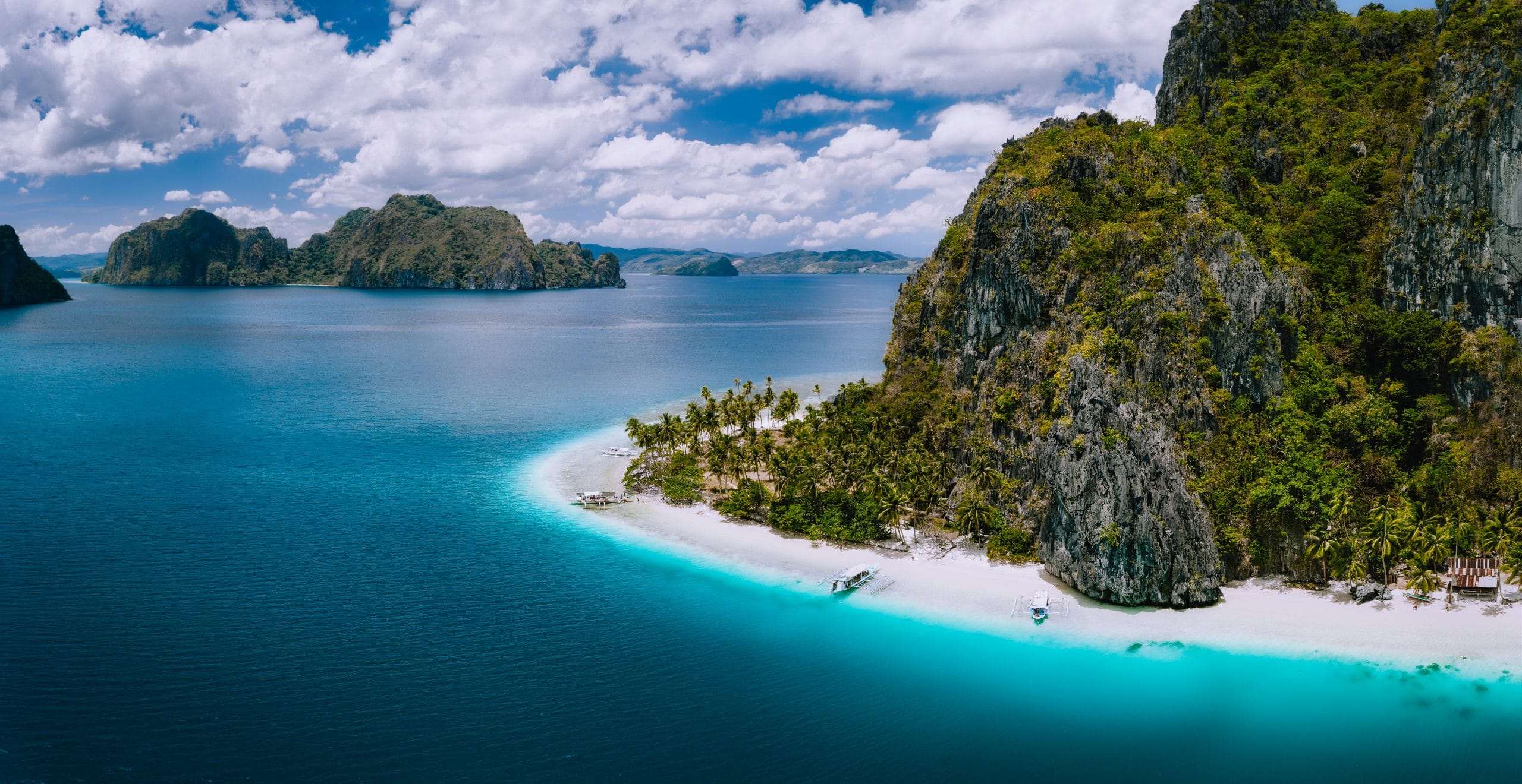 El Nido, Palawan, Philippines. Aerial drone shot of Ipil beach located on Pinagbuyutan Island. Amazing white sand, coconut palm trees and turquoise blue ocean water.