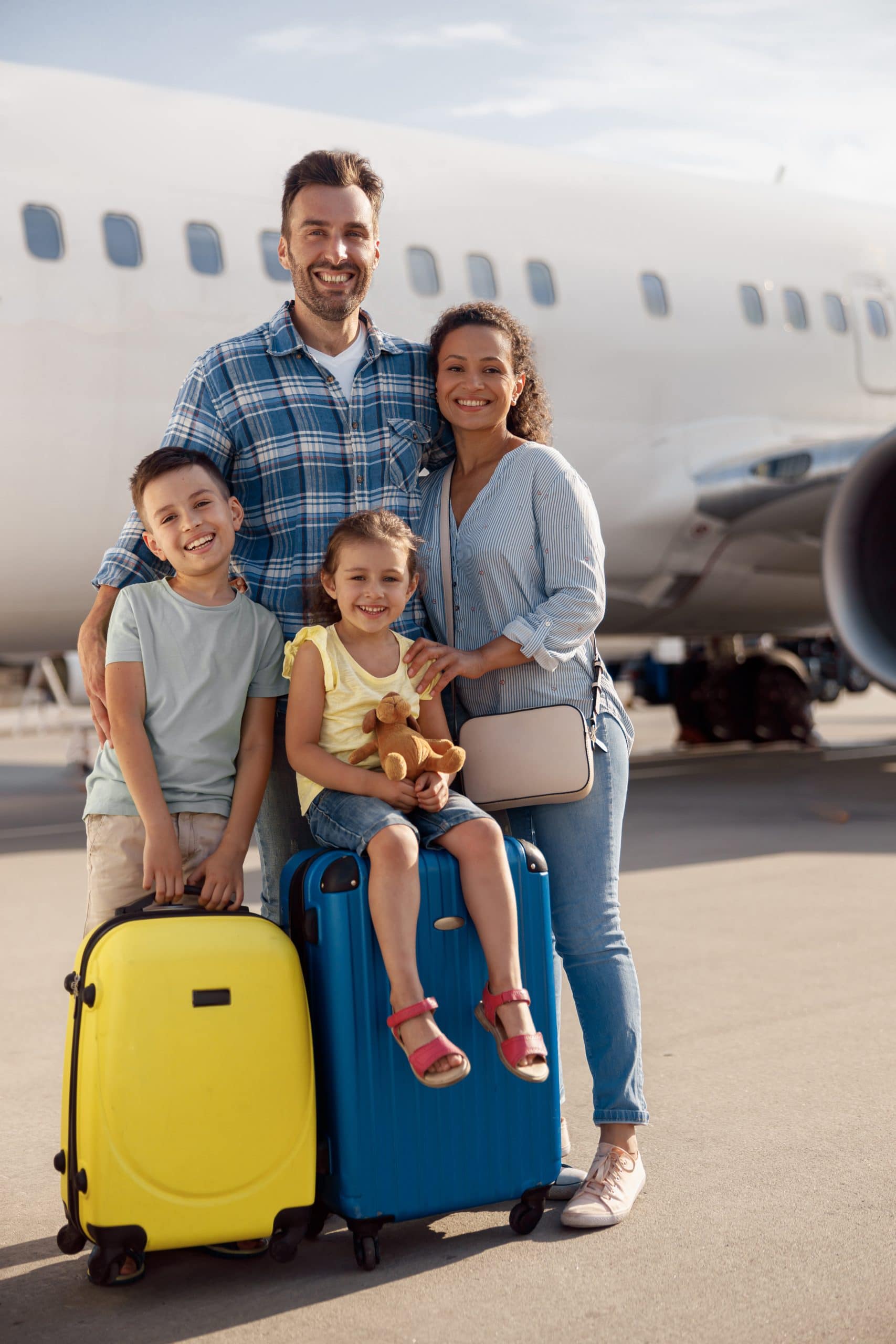 Family arriving at an airport with luggage before departing on holiday.