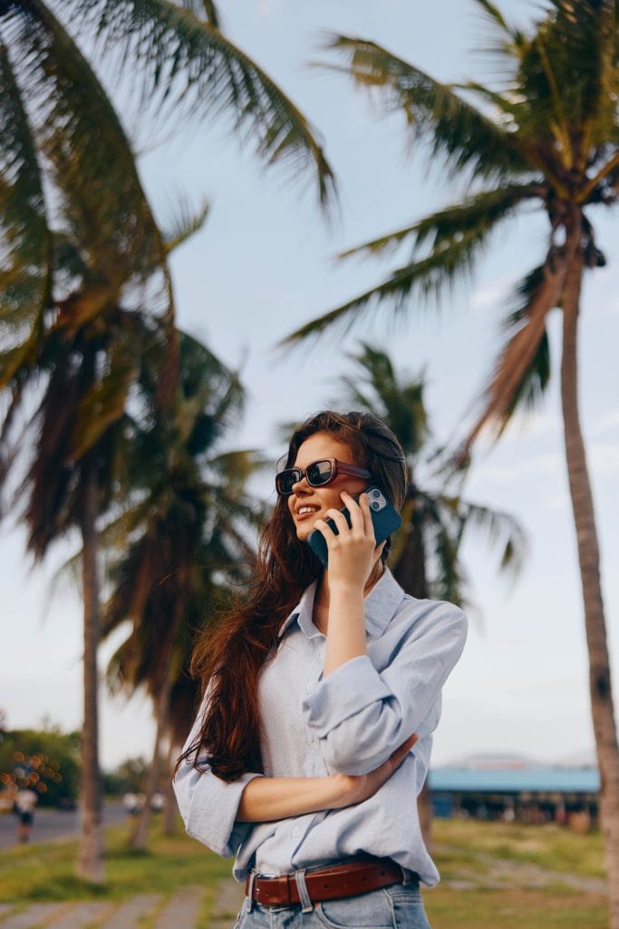 Traveller using a smartphone outdoors while staying connected during a trip.
